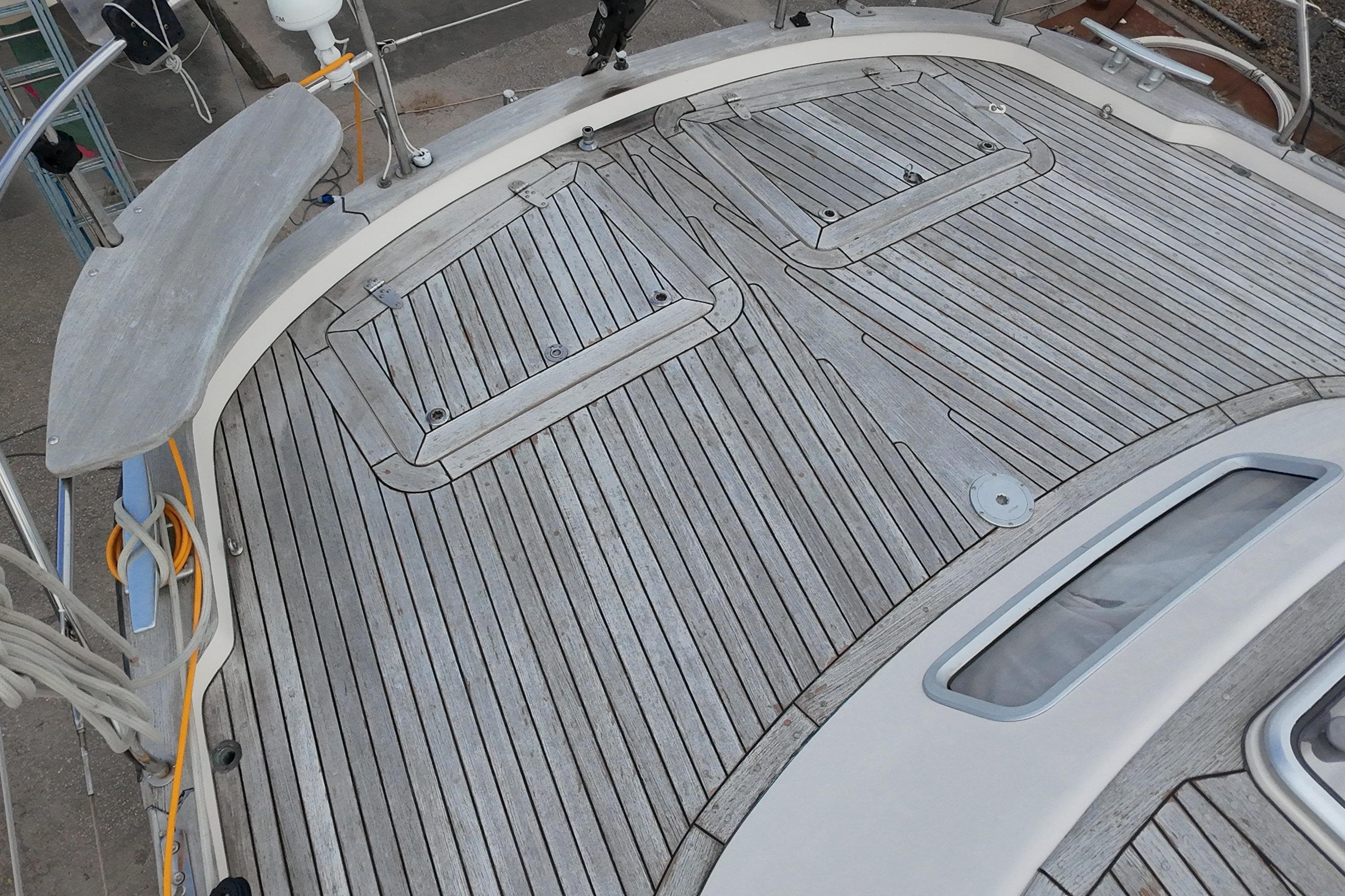 Teak deck of a 2000 Hallberg-Rassy 46 sailboat, showcasing elegant craftsmanship.