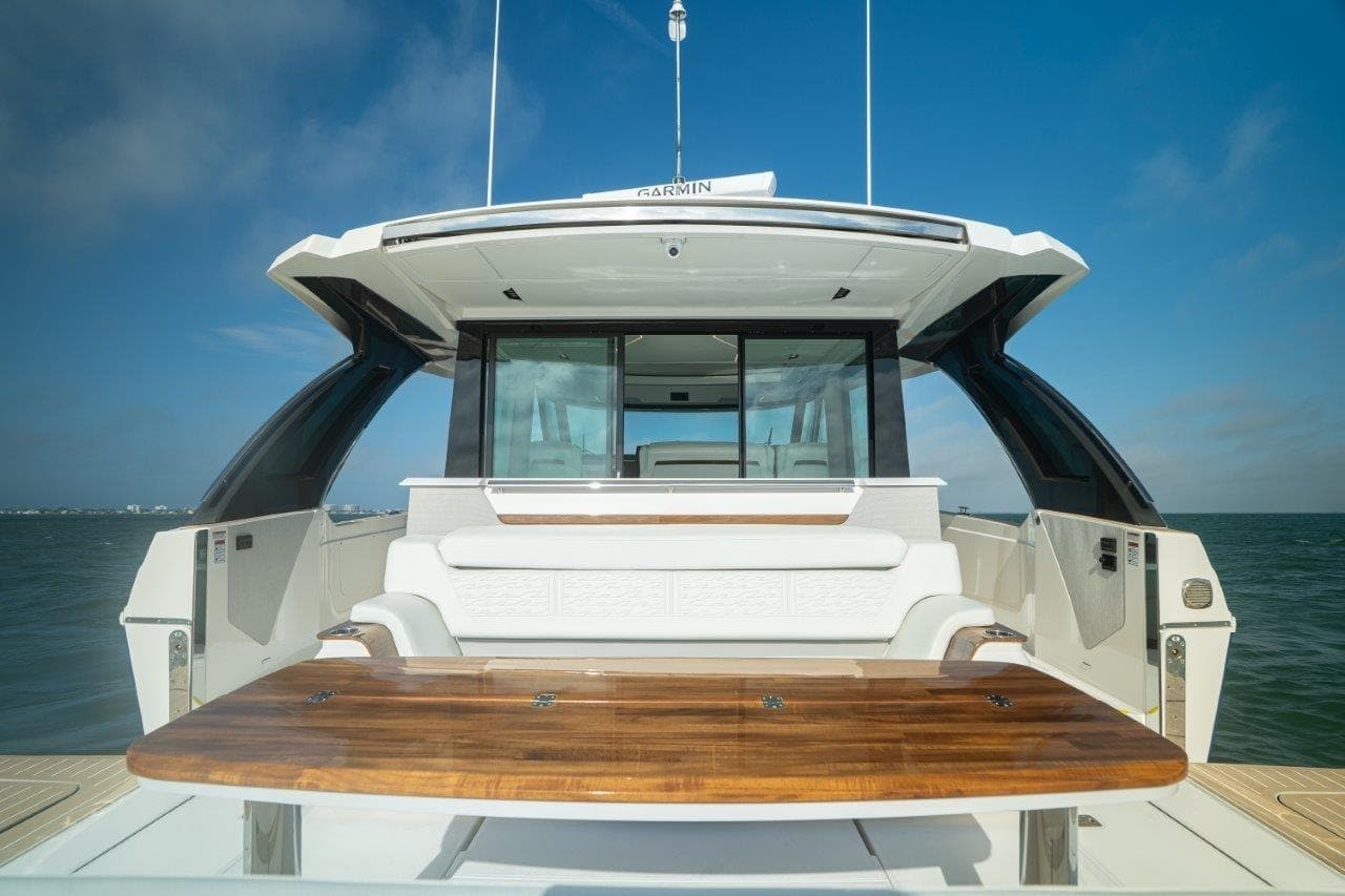 2026 Tiara Yachts 56 LS luxury yacht with elegant seating and wooden table on deck.