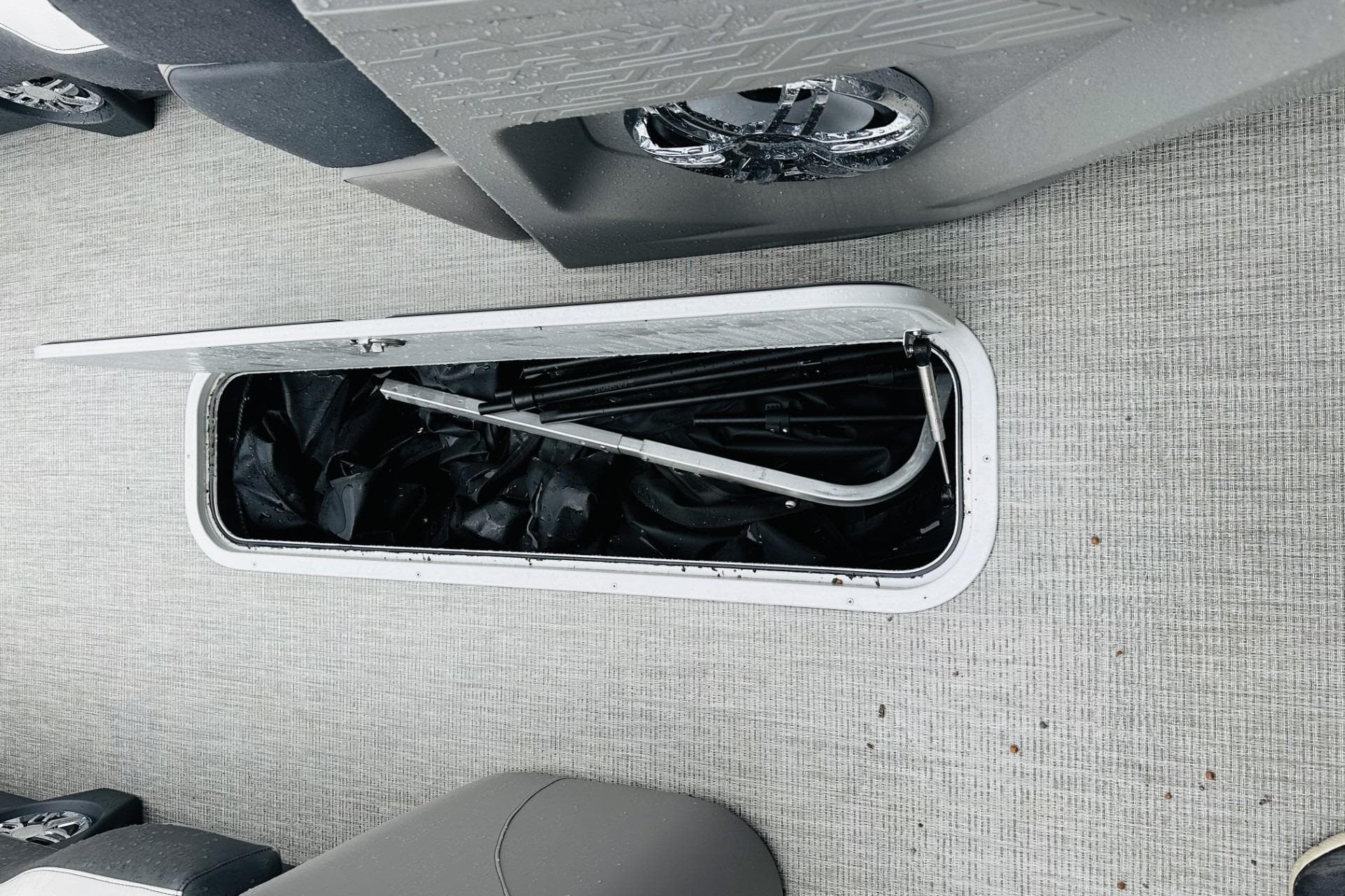 Open storage compartment on 2025 Avalon Catalina Cruise Funship boat, showing interior contents.