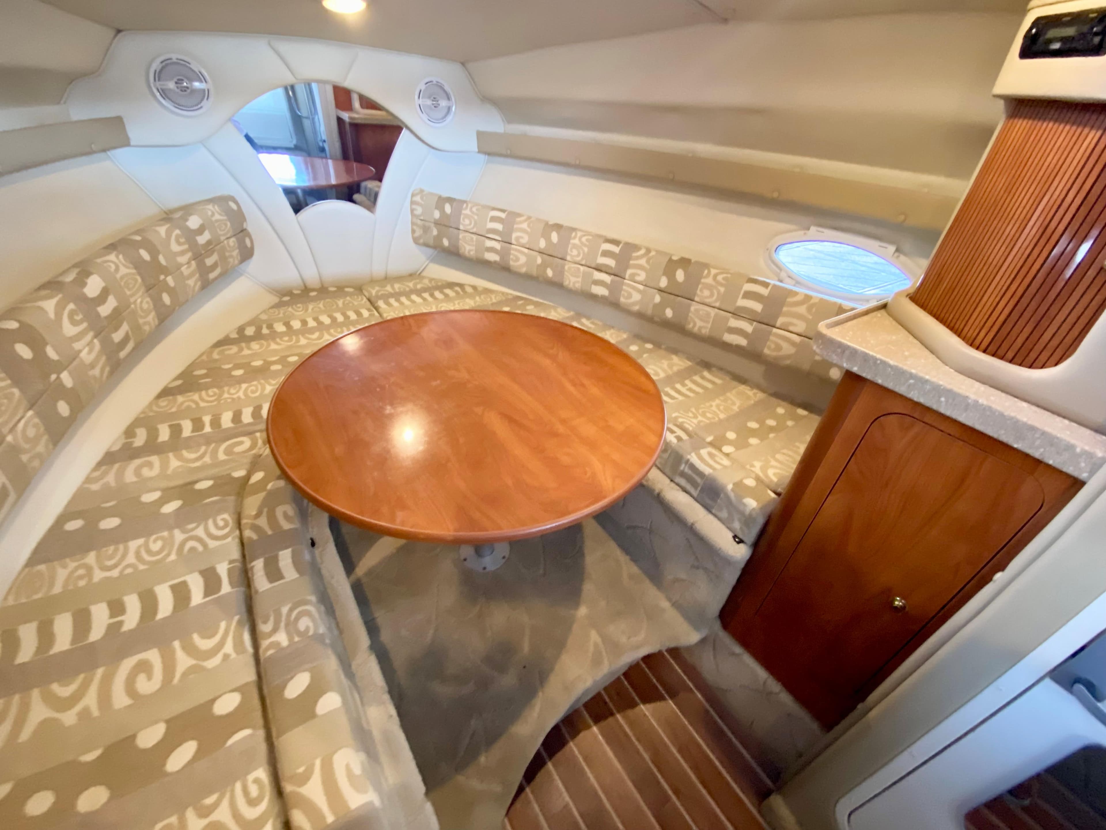 Interior of 2005 Rinker 270 Express Cruiser with table and seating area.