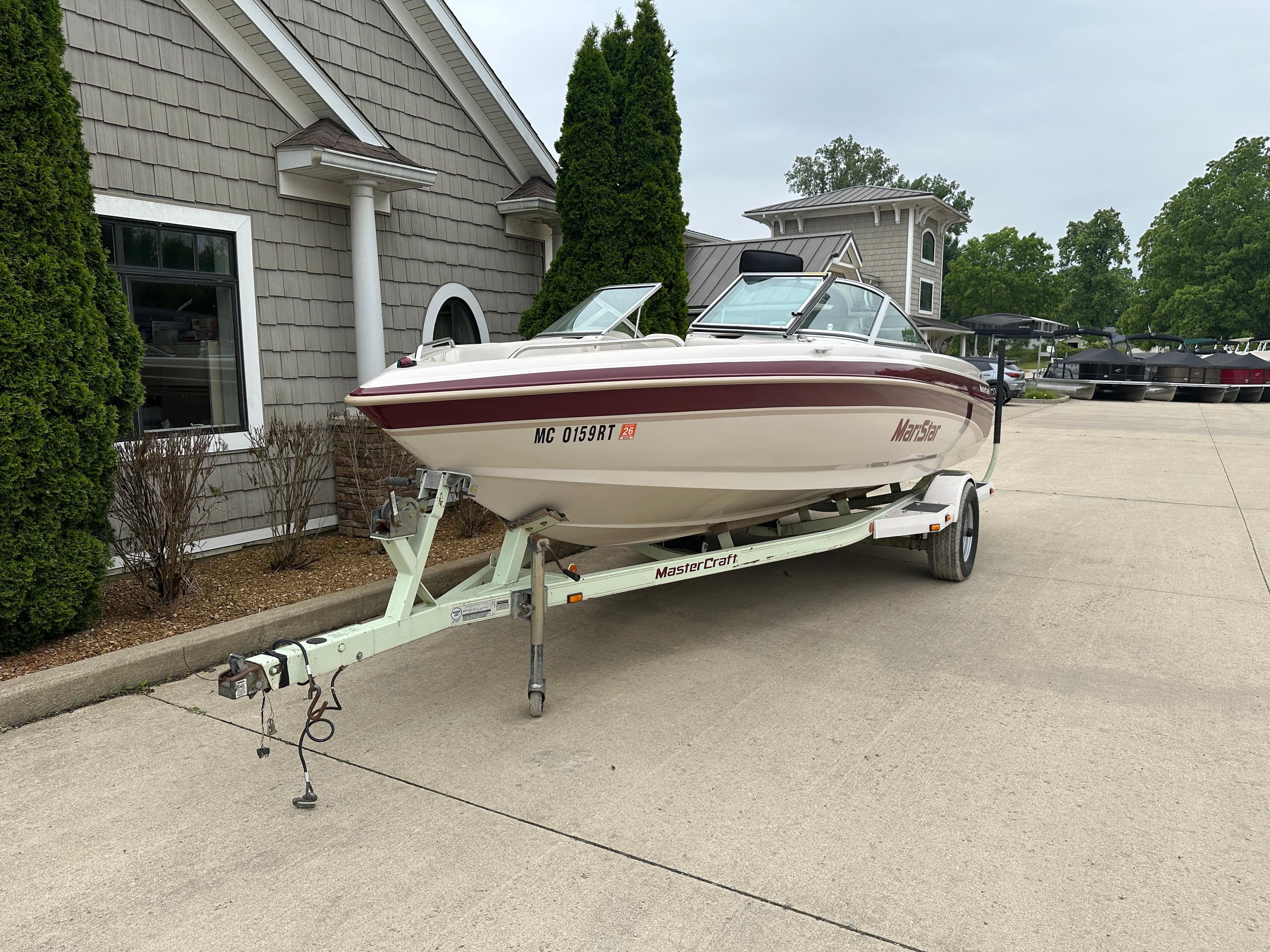 1999 MasterCraft MariStar 210 VRS boat on trailer, parked in driveway.