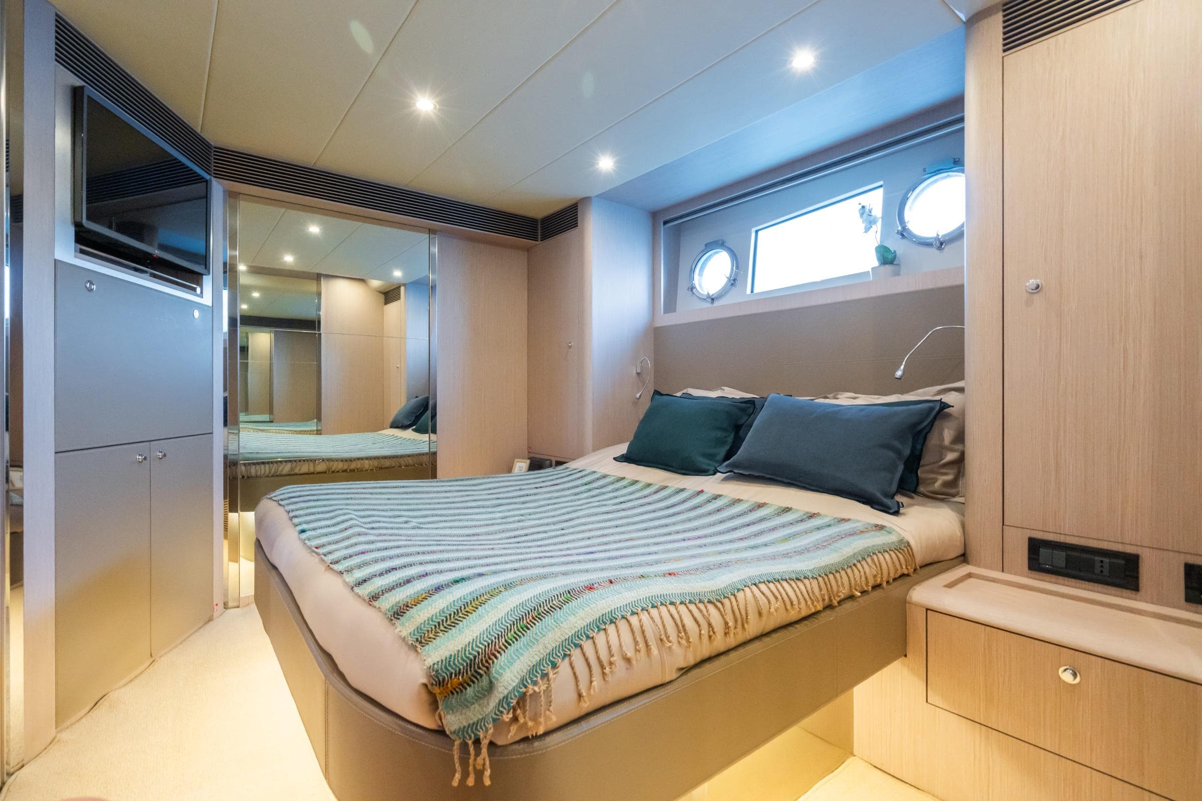 Luxurious cabin interior of 2015 Riva 63 Vertigo yacht with cozy bed and modern design.