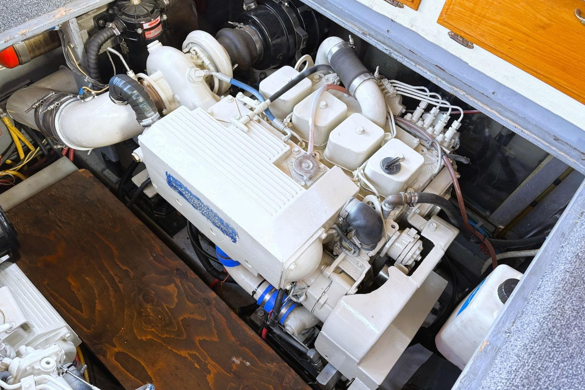 Engine compartment of a 1980 Tollycraft 34 Sedan boat, showcasing detailed machinery.