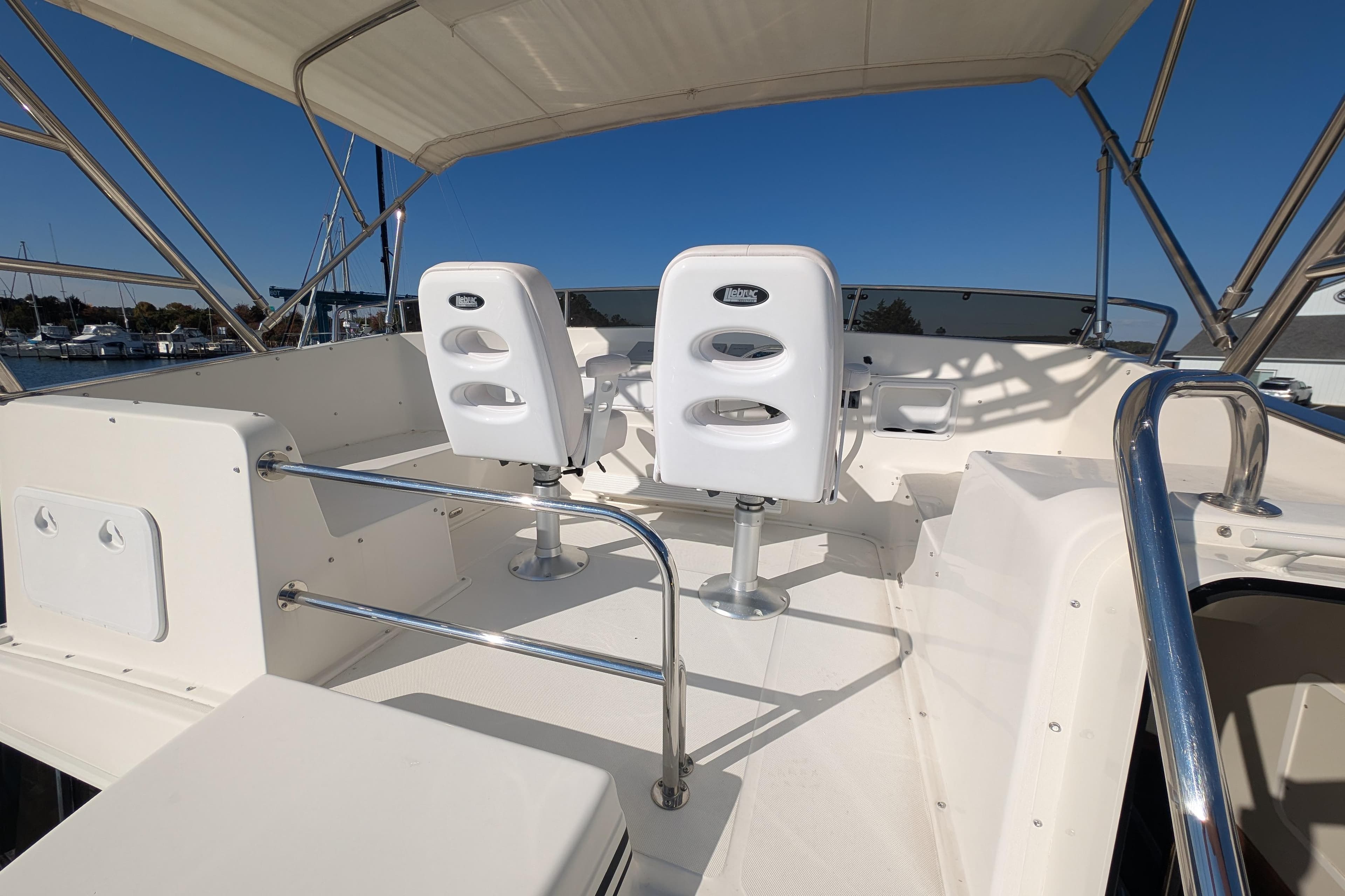 Flybridge of 2015 American Tug 435 with helm seats and stainless steel railings.