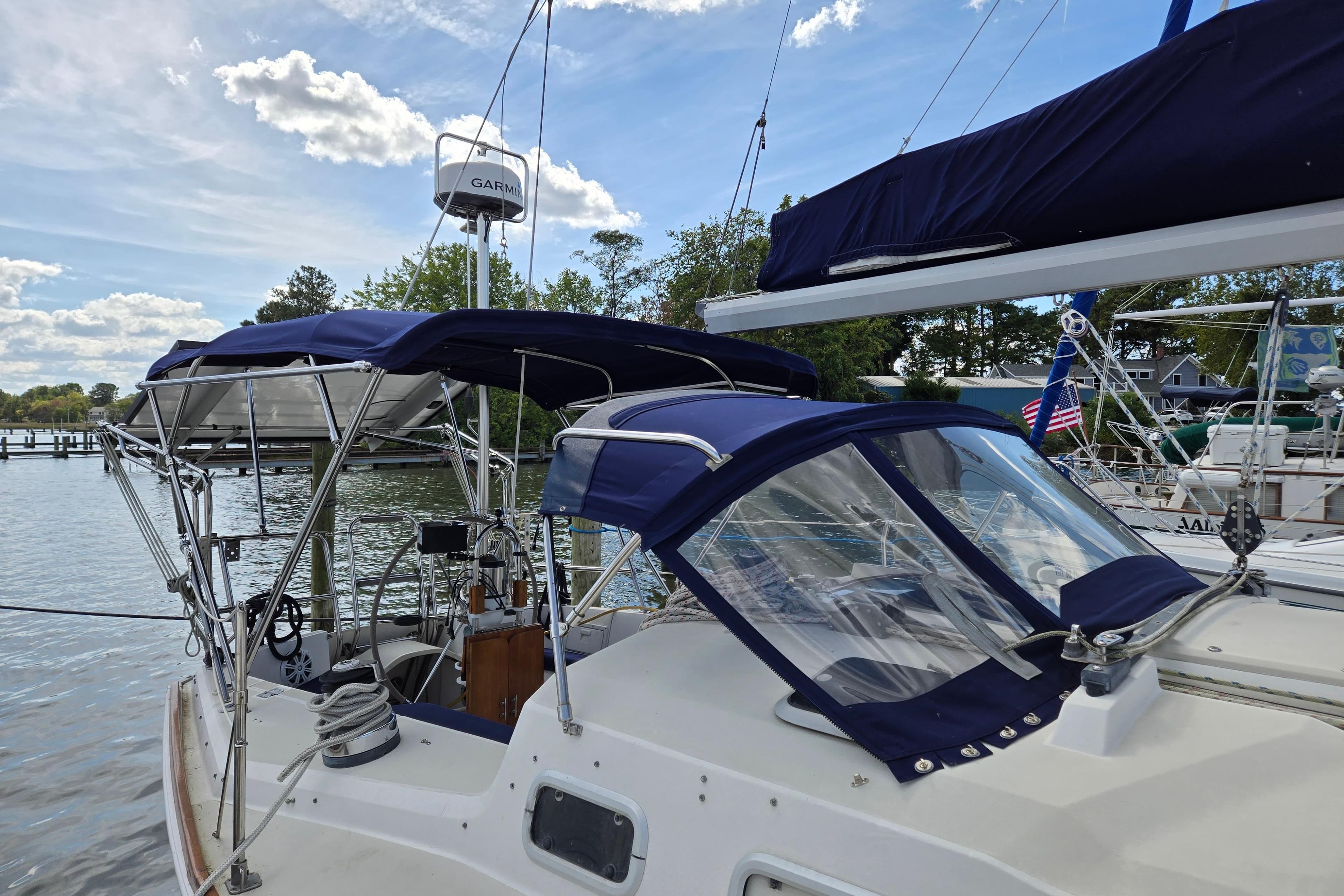 Sailboat docked with blue canopy, Pearson 37-2, 1989 model, clear sky background.
