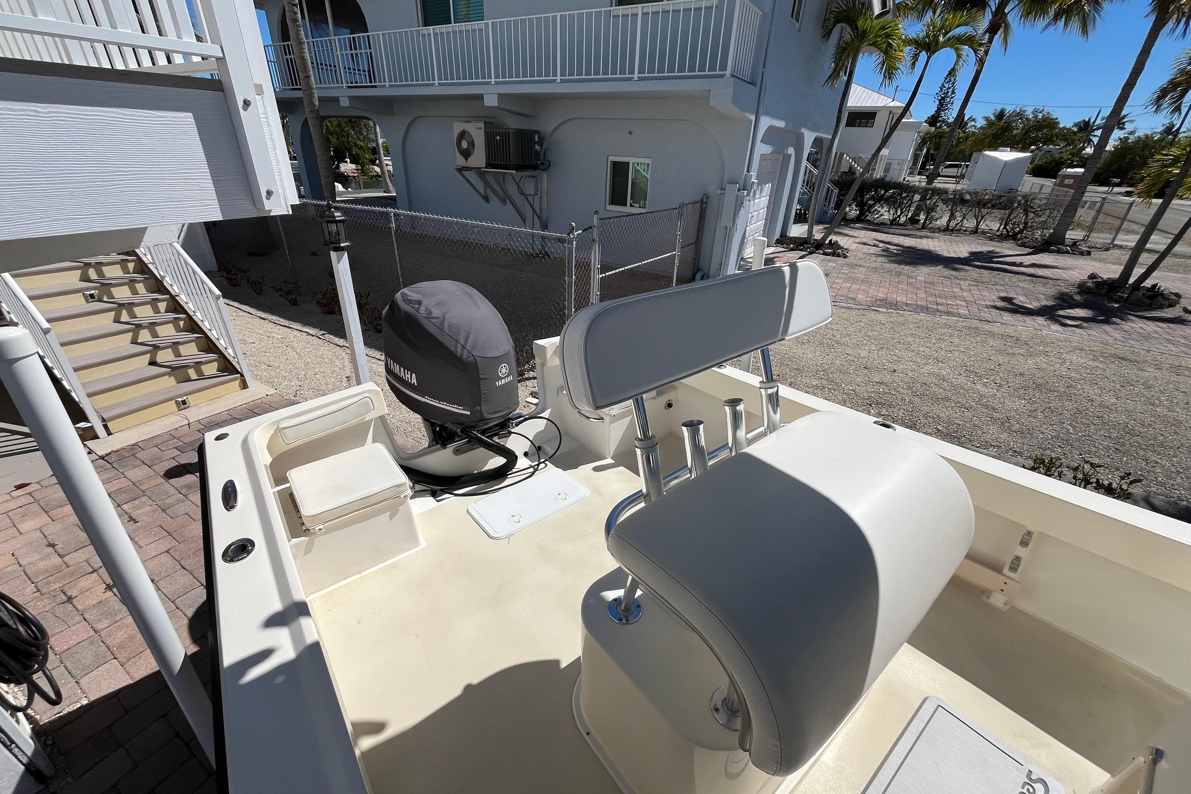 2009 Parker 2300 Special Edition boat with Yamaha engine, parked near a coastal home.