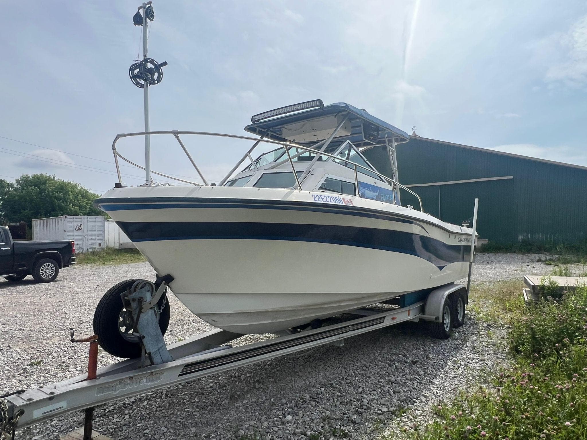 1988 Grady-White Offshore 240 boat on trailer, parked outdoors on gravel.