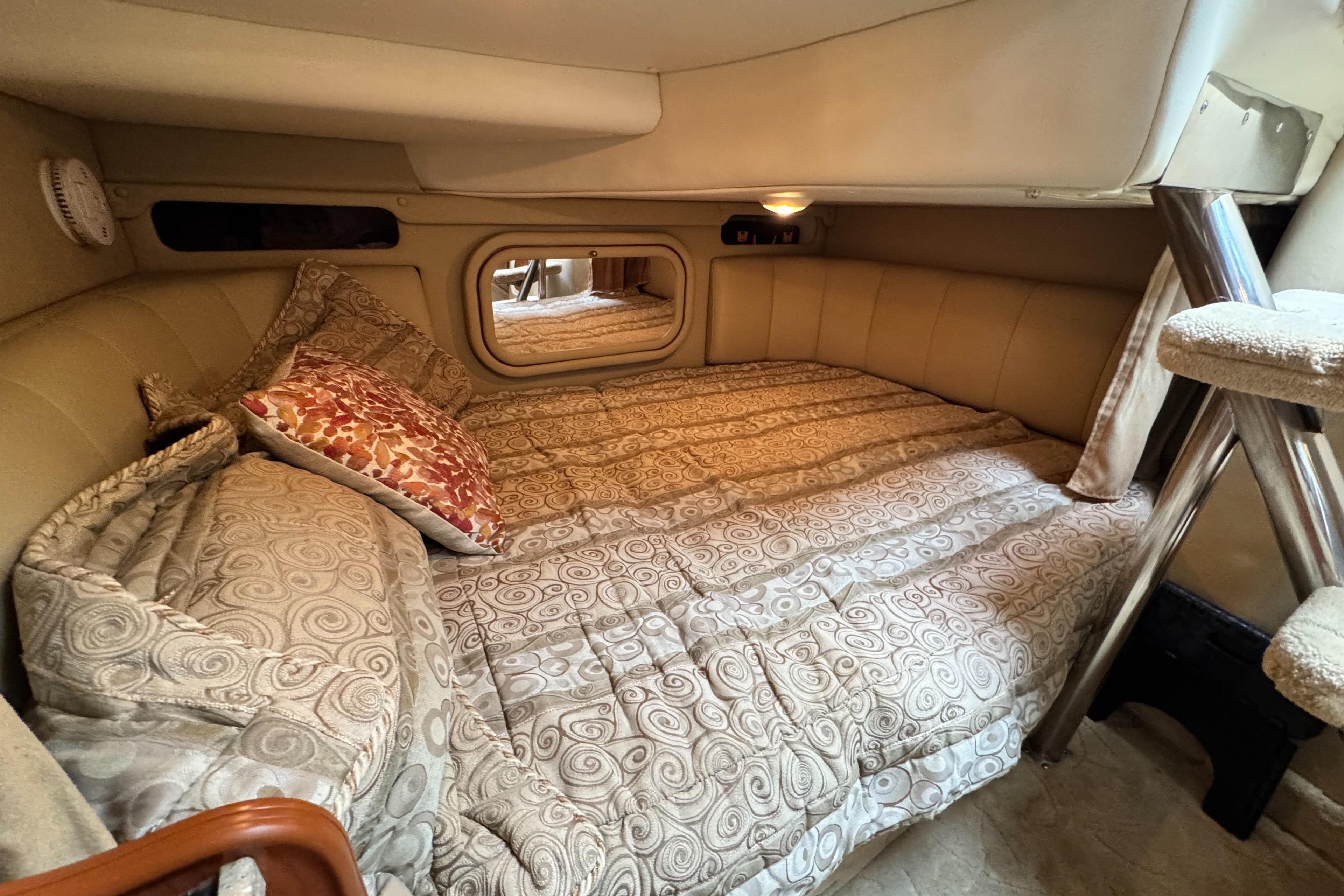 2005 Rinker Fiesta Vee 342 cabin interior with cozy bed and patterned bedding.