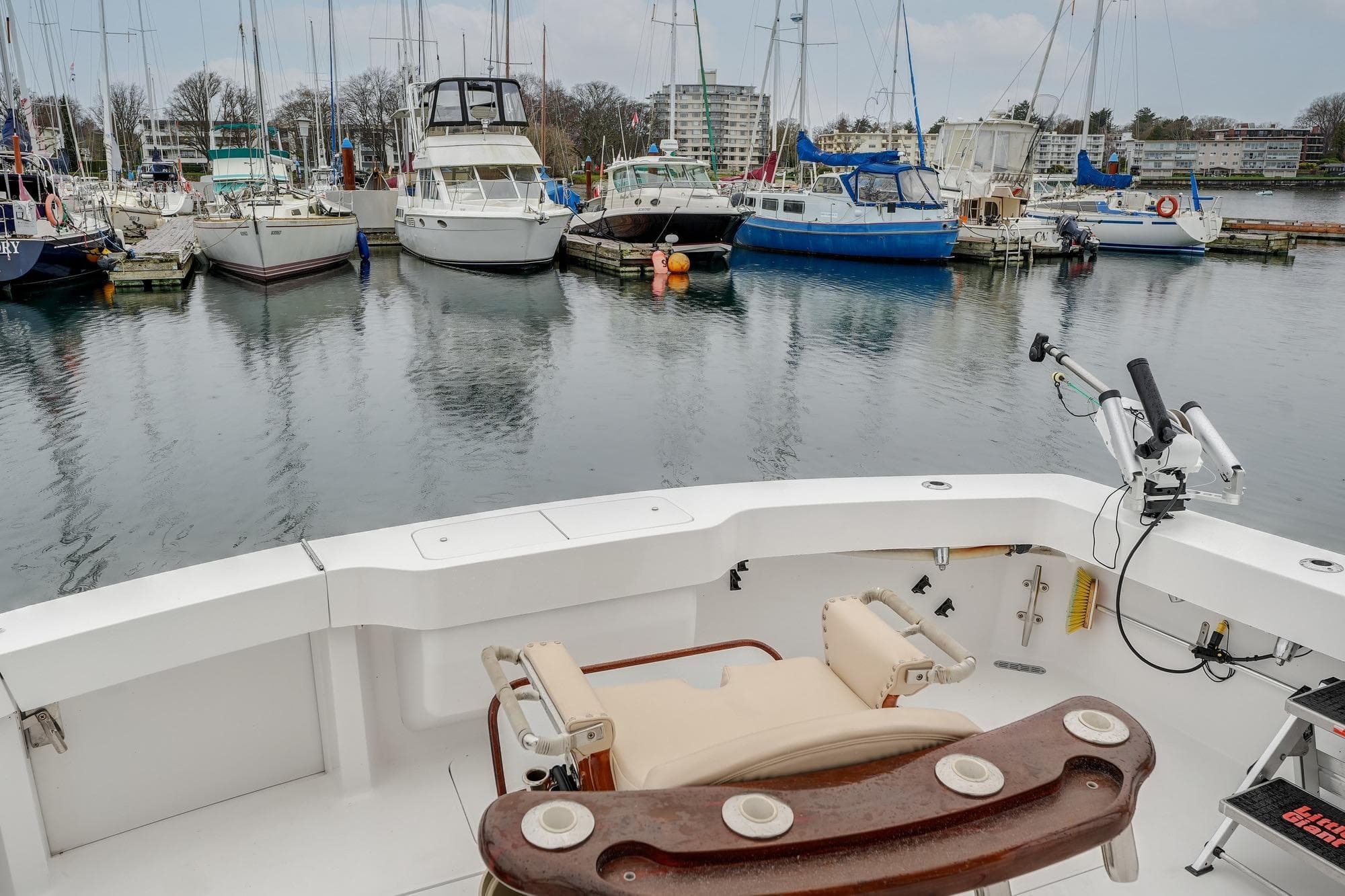 1992 Viking 43 Open boat at marina with surrounding sailboats and calm water.