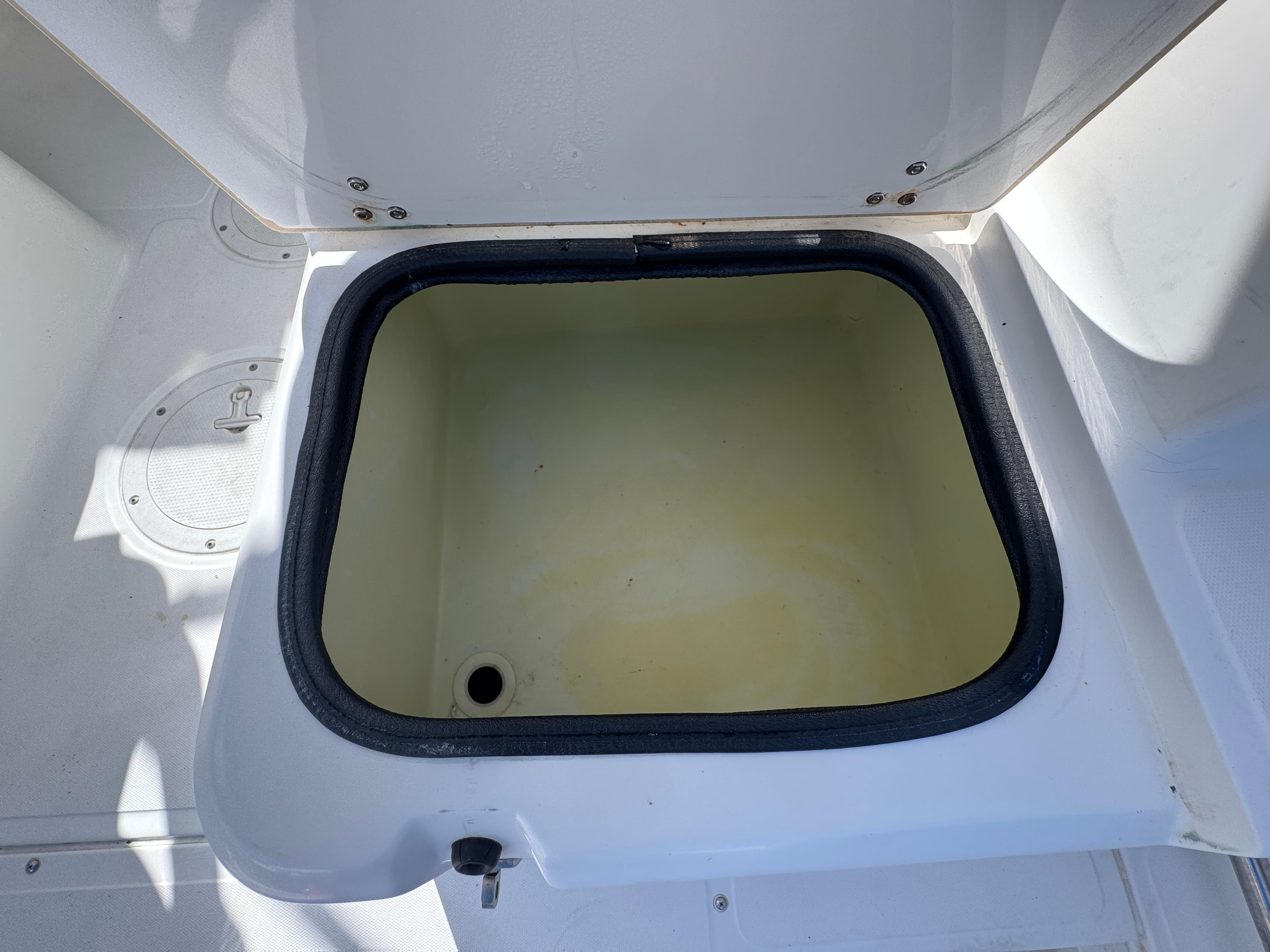 Open storage compartment on a 1999 Boston Whaler Conquest 23 boat.