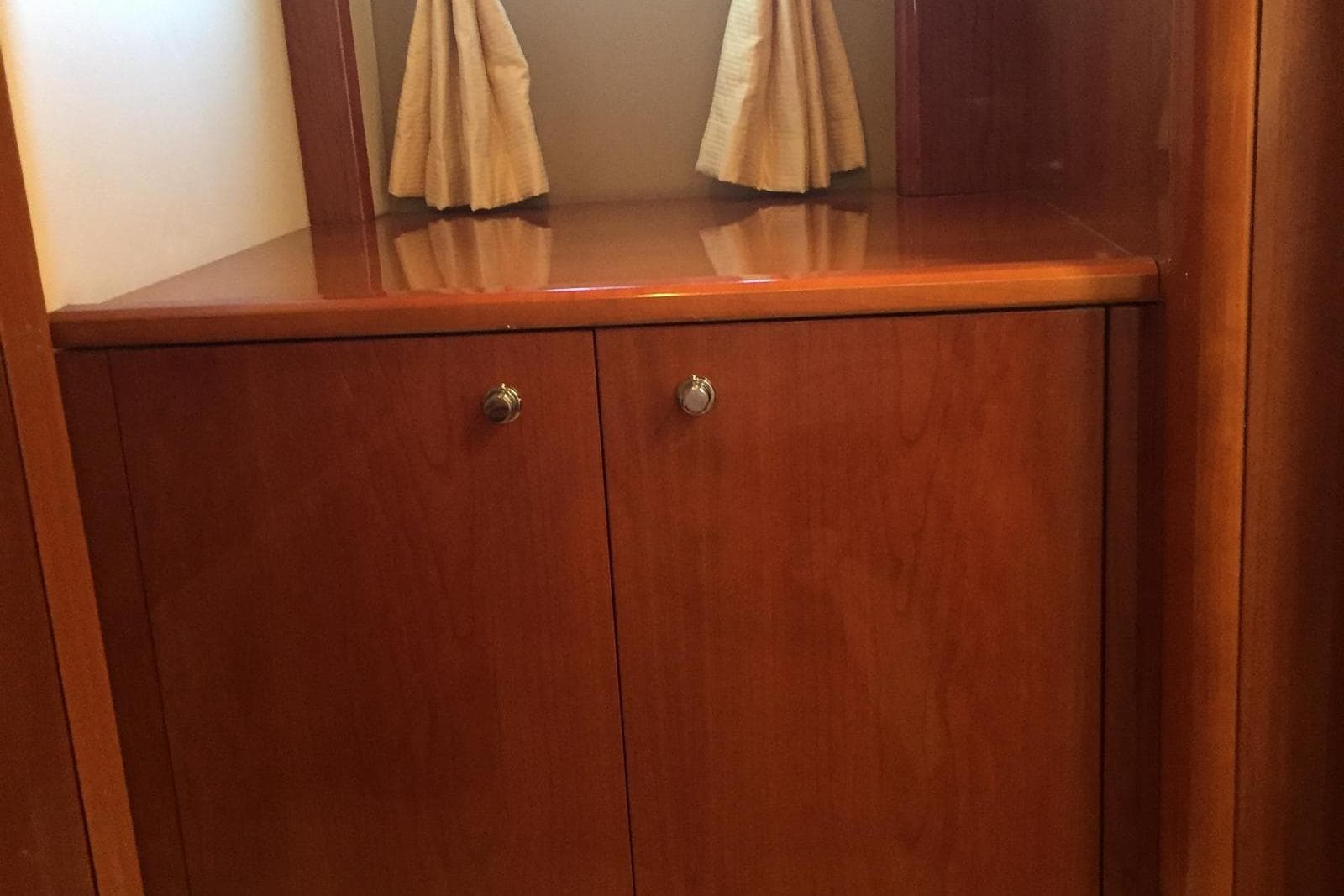 Wooden cabinet with curtains inside a 2006 Princess V48 yacht interior.