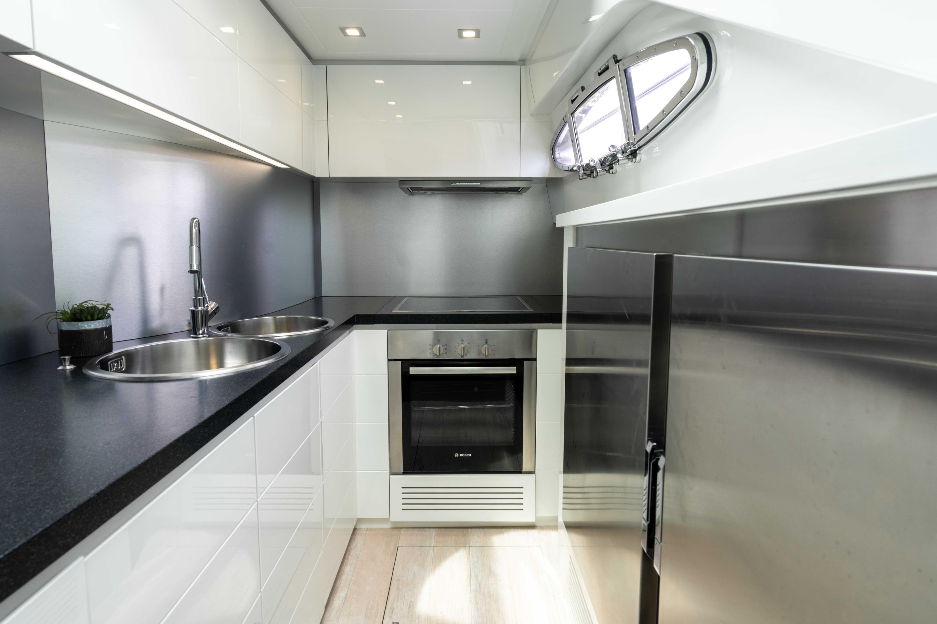 Modern kitchen interior on 2017 Pershing 74 yacht, featuring sleek design and stainless steel appliances.