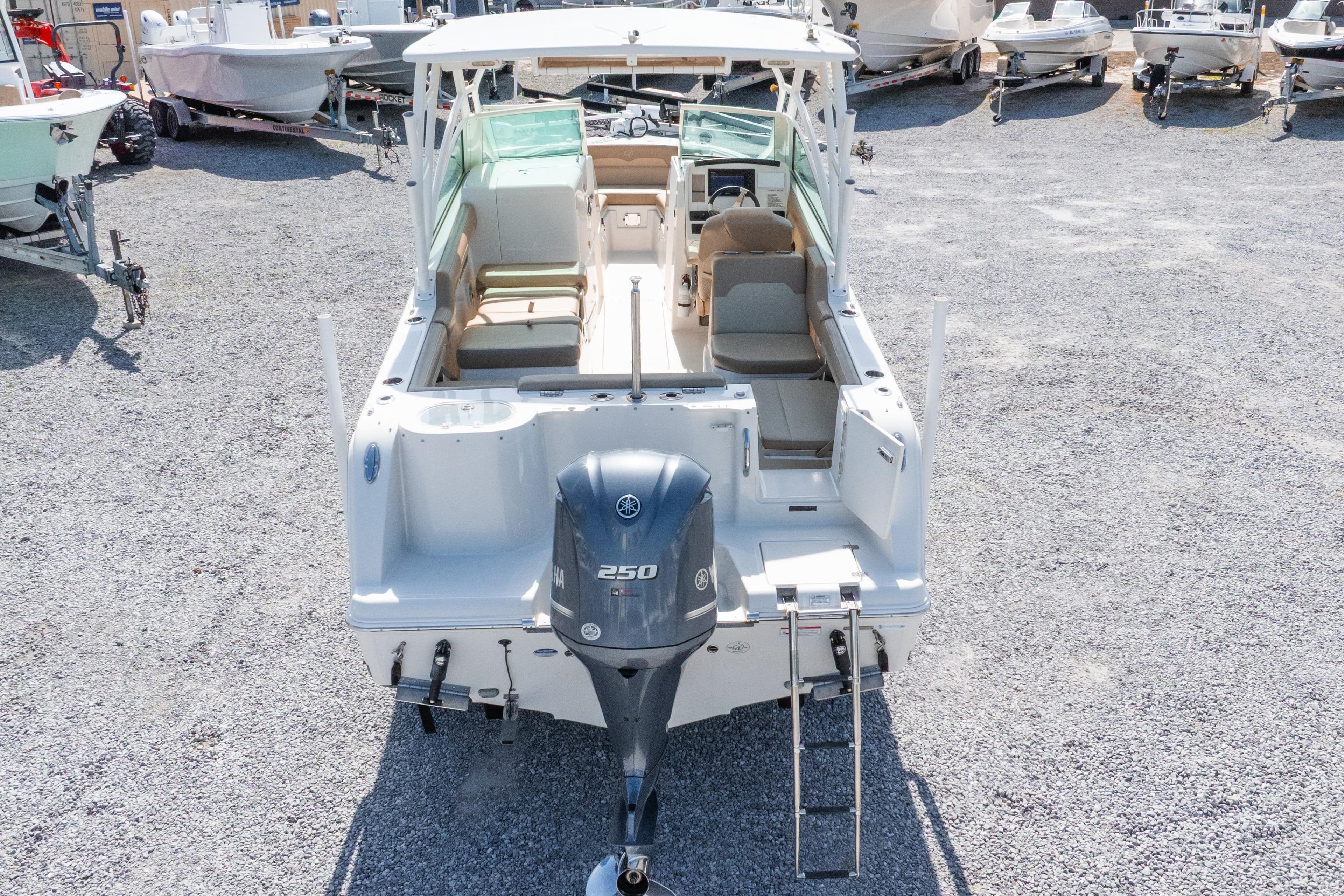 2018 Sailfish 245 DC boat with Yamaha 250 engine, parked on gravel lot.