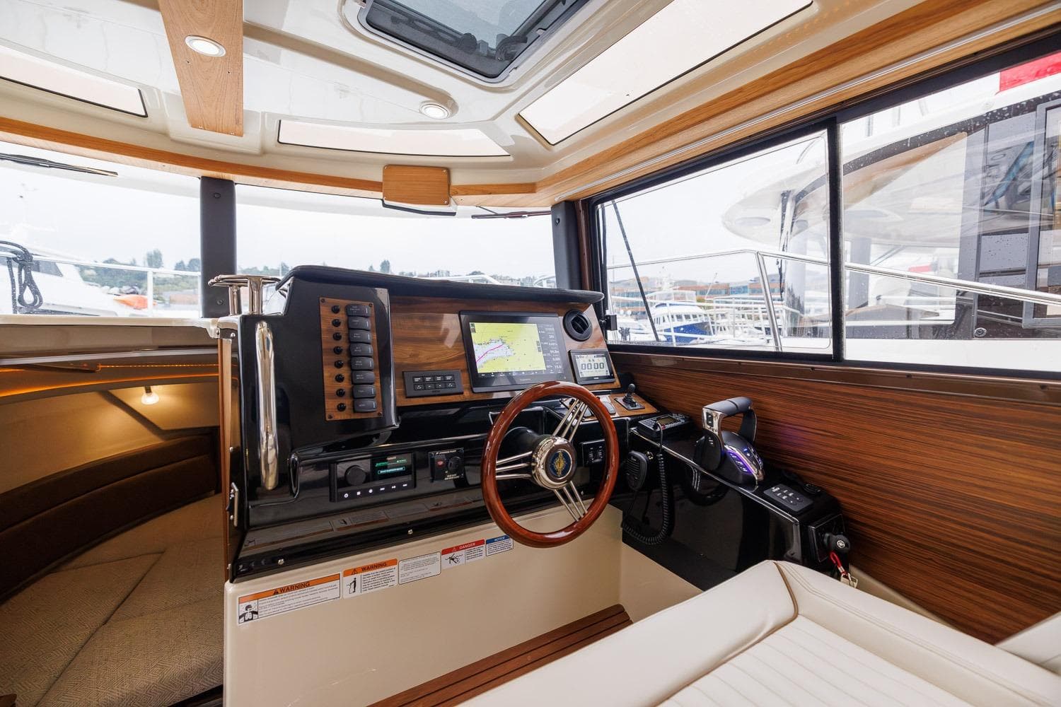 Interior of 2026 Ranger Tugs R-27 boat, featuring modern navigation controls and wooden accents.
