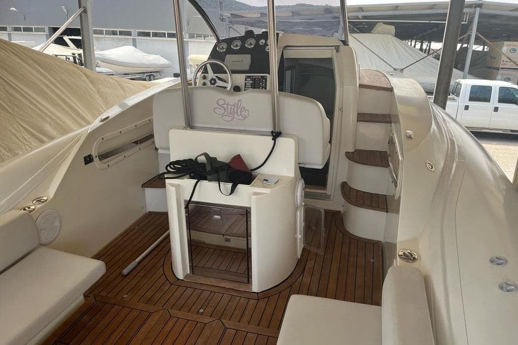 Interior of a 2016 Albatro 32 boat with wooden flooring and steering console.