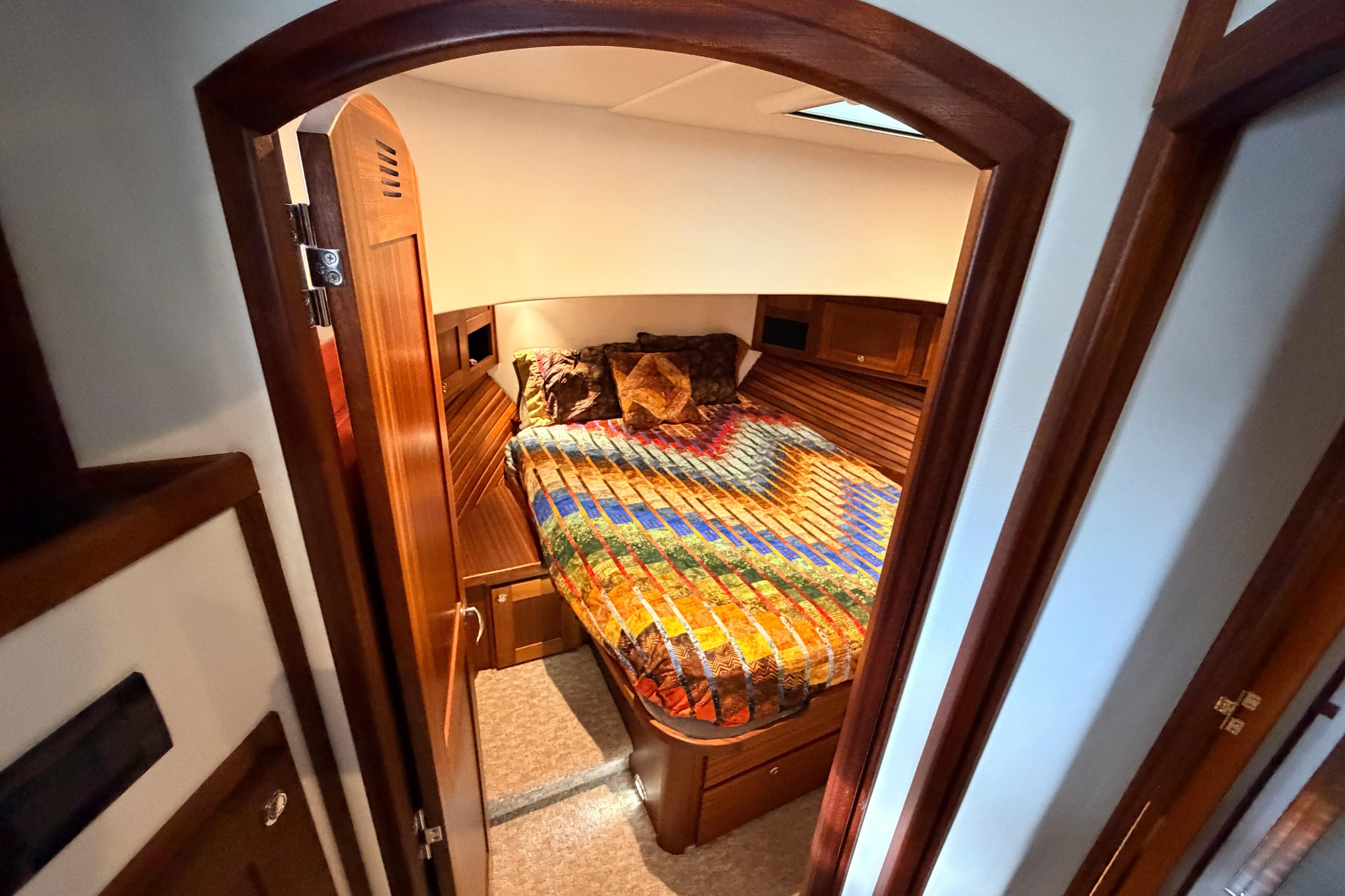 Cozy cabin interior of 2022 American Tug 365 with colorful bedding and wooden accents.