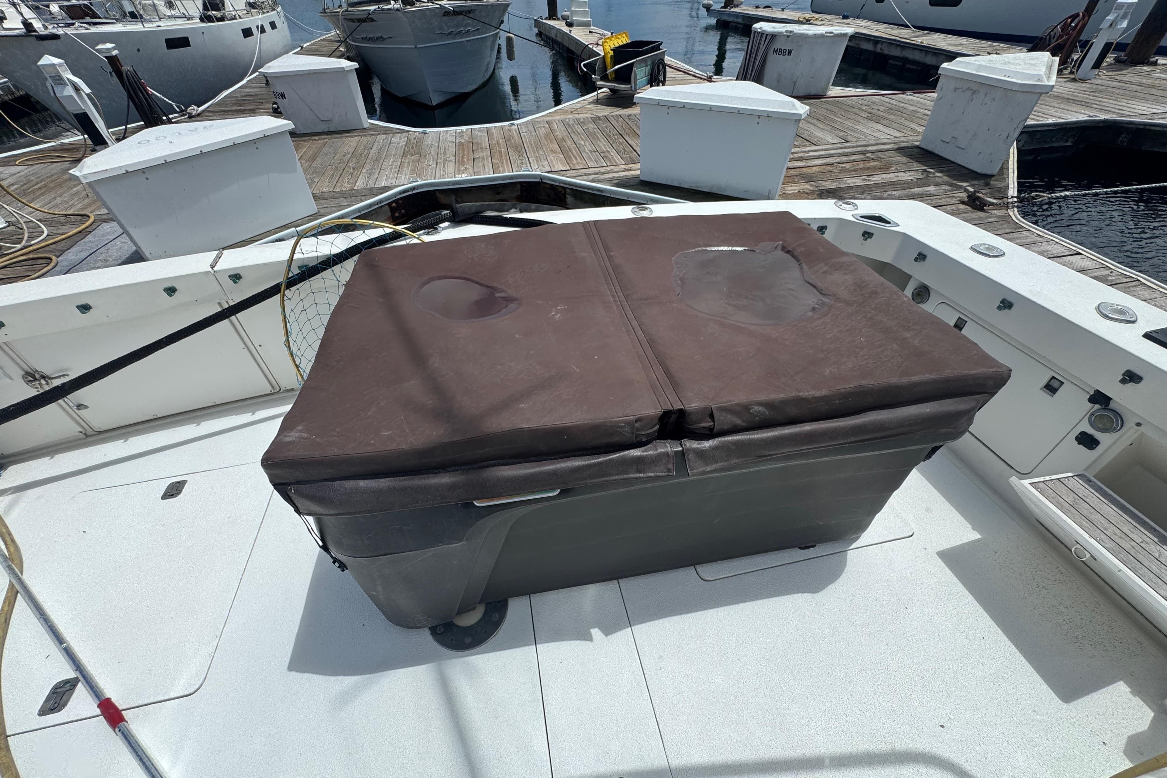 1988 Bertram 50 Convertible boat deck with covered storage box at marina.