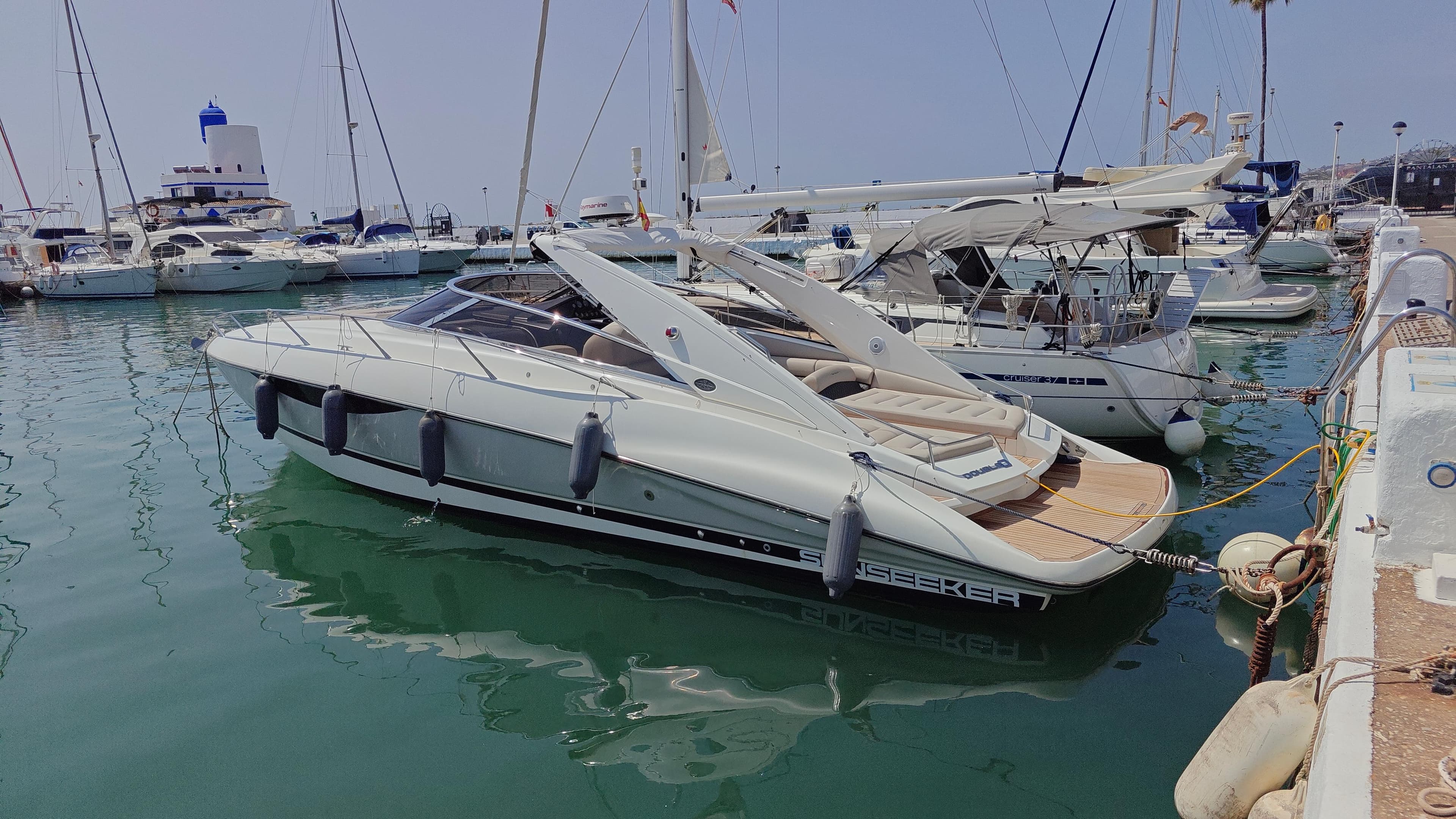 2007 Sunseeker Superhawk 43 yacht docked in a marina, surrounded by other boats.