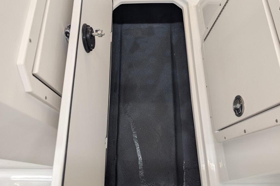 2025 Starcraft SVX 210 IO boat storage compartment with open hatch and sleek interior design.