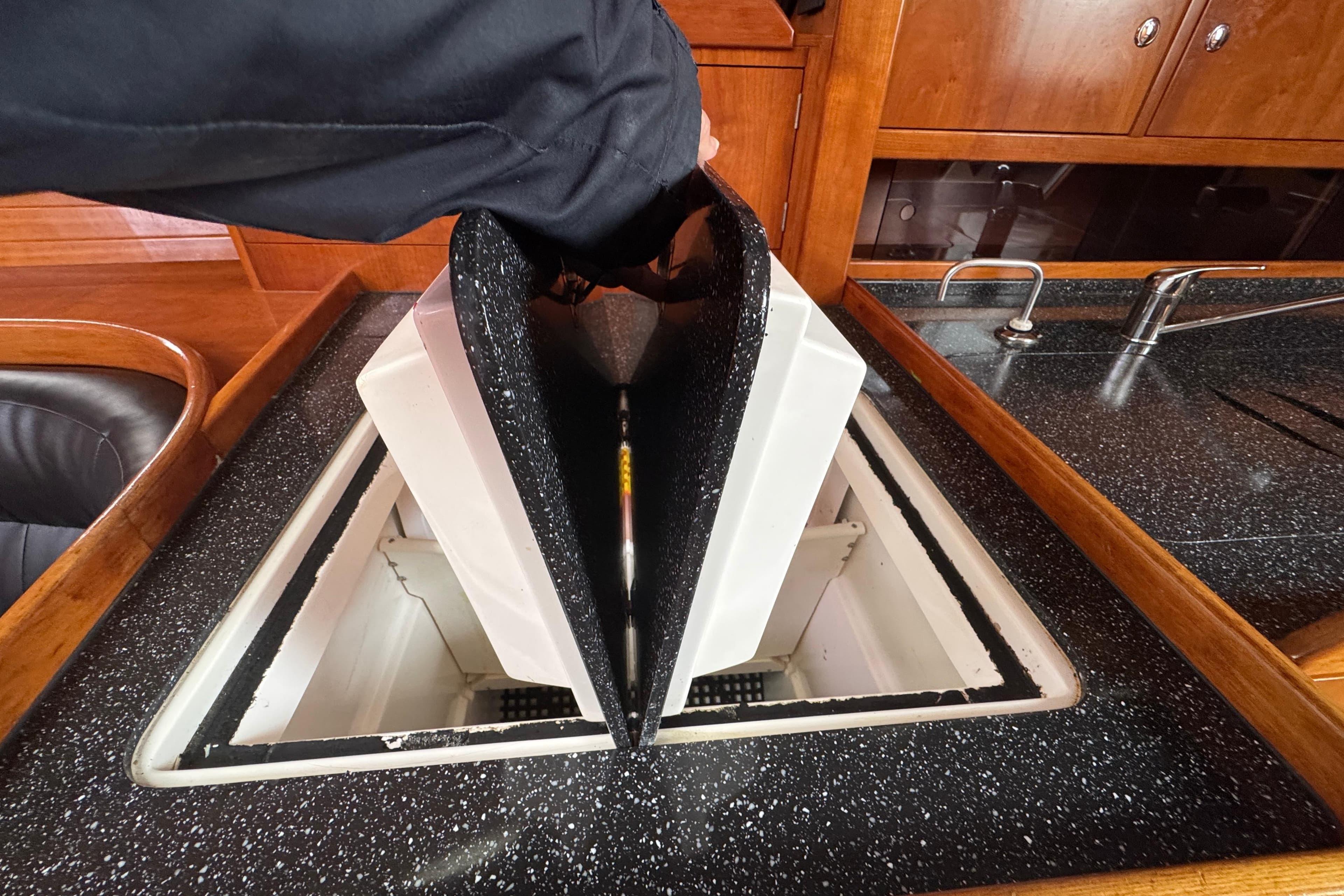 Opening hatch in 2004 Alliaura FEELING 44 DI yacht kitchen, revealing storage compartment.