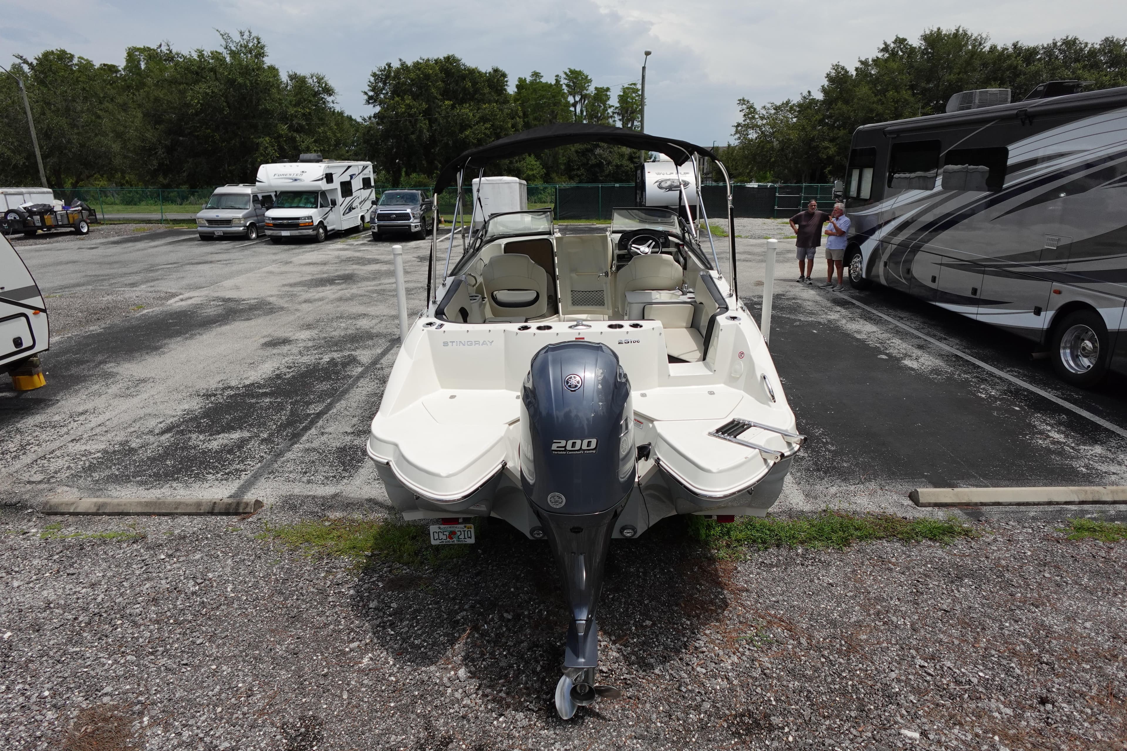 2022 Stingray 231 DC boat parked in a lot with RVs and cars.