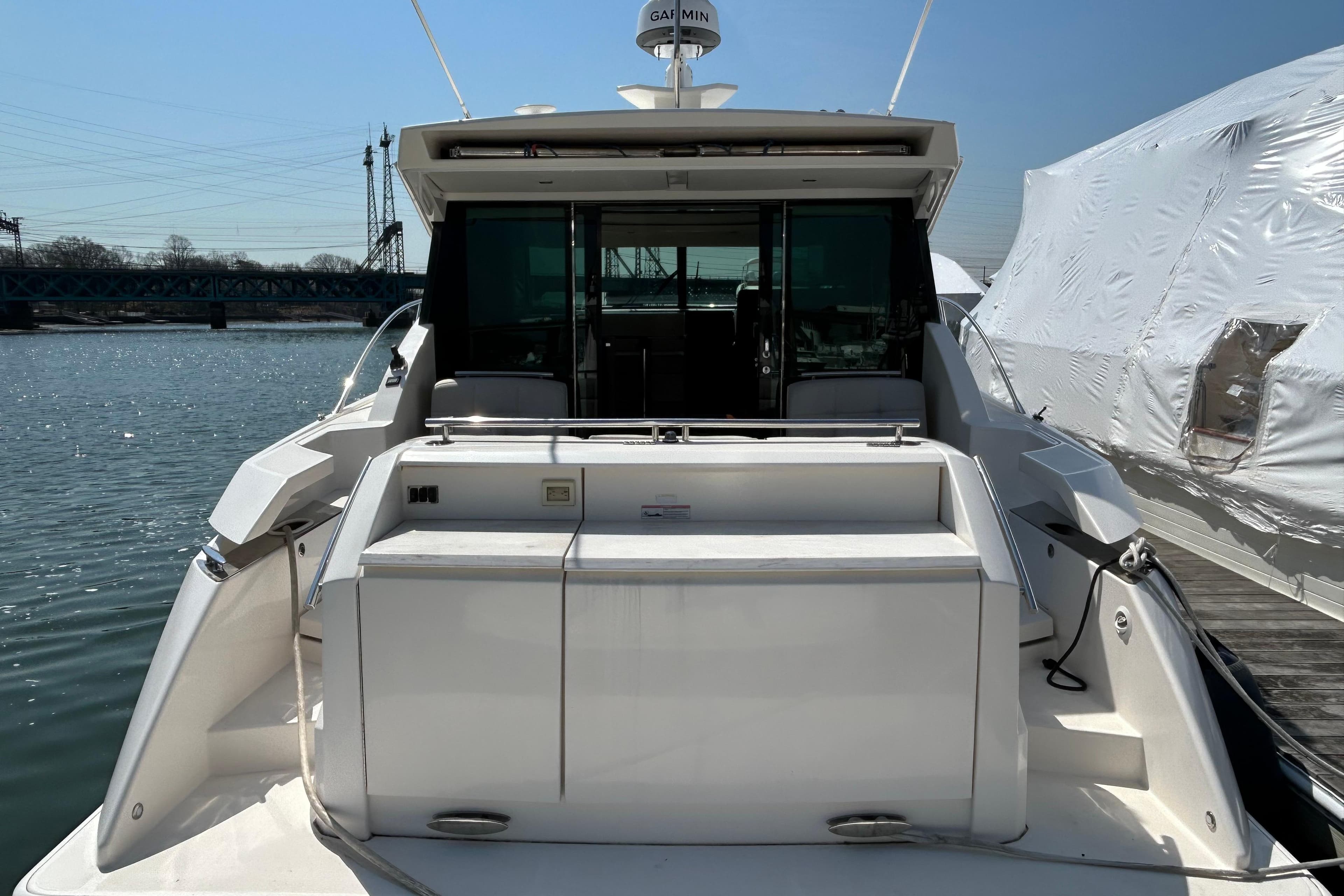 2016 Tiara Yachts C44 Coupe docked, rear view with open cockpit and water backdrop.
