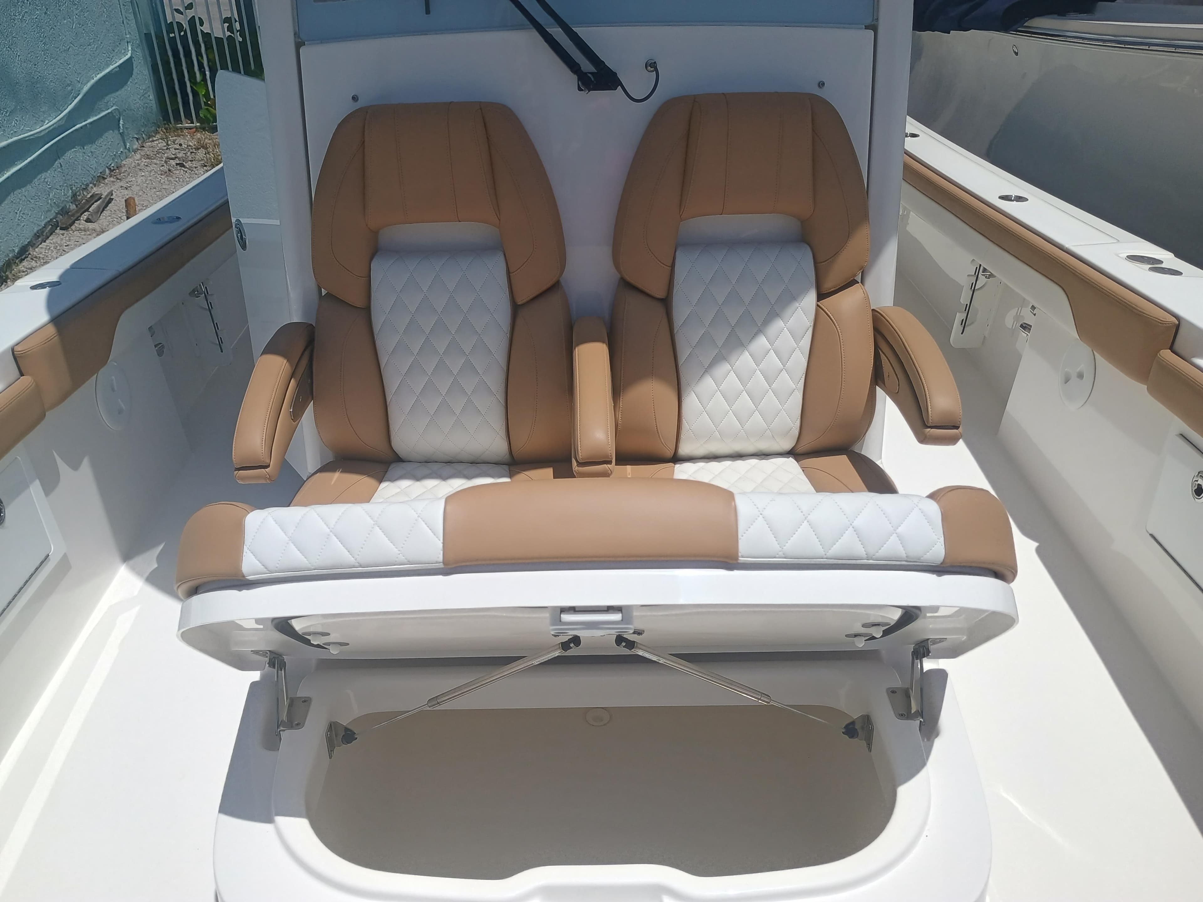 2025 Regulator 30XO boat seats with storage compartment, featuring tan and white upholstery.
