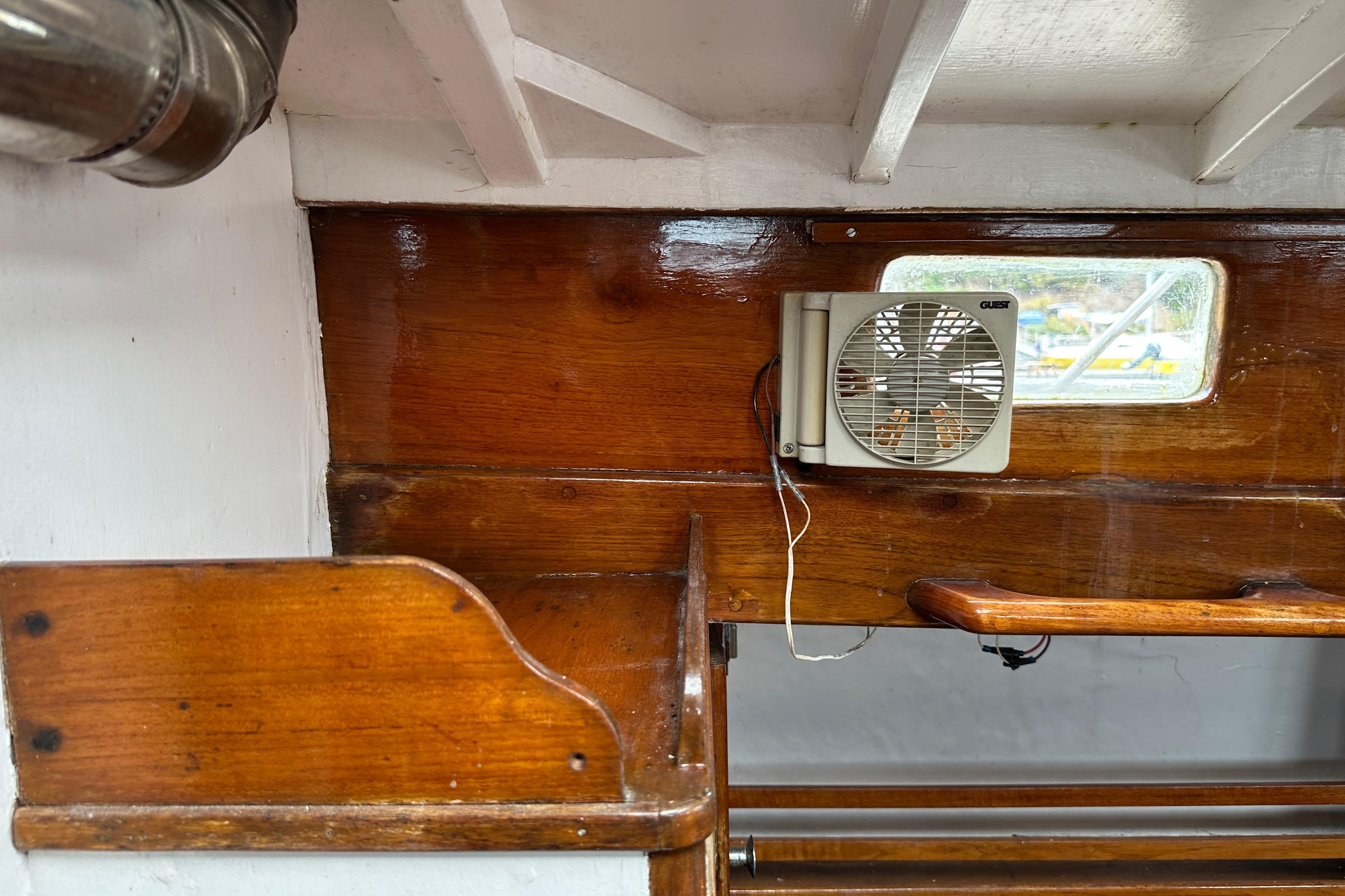 Interior of 1964 Cheoy Lee Lion Class Sloop with wooden paneling and small fan.