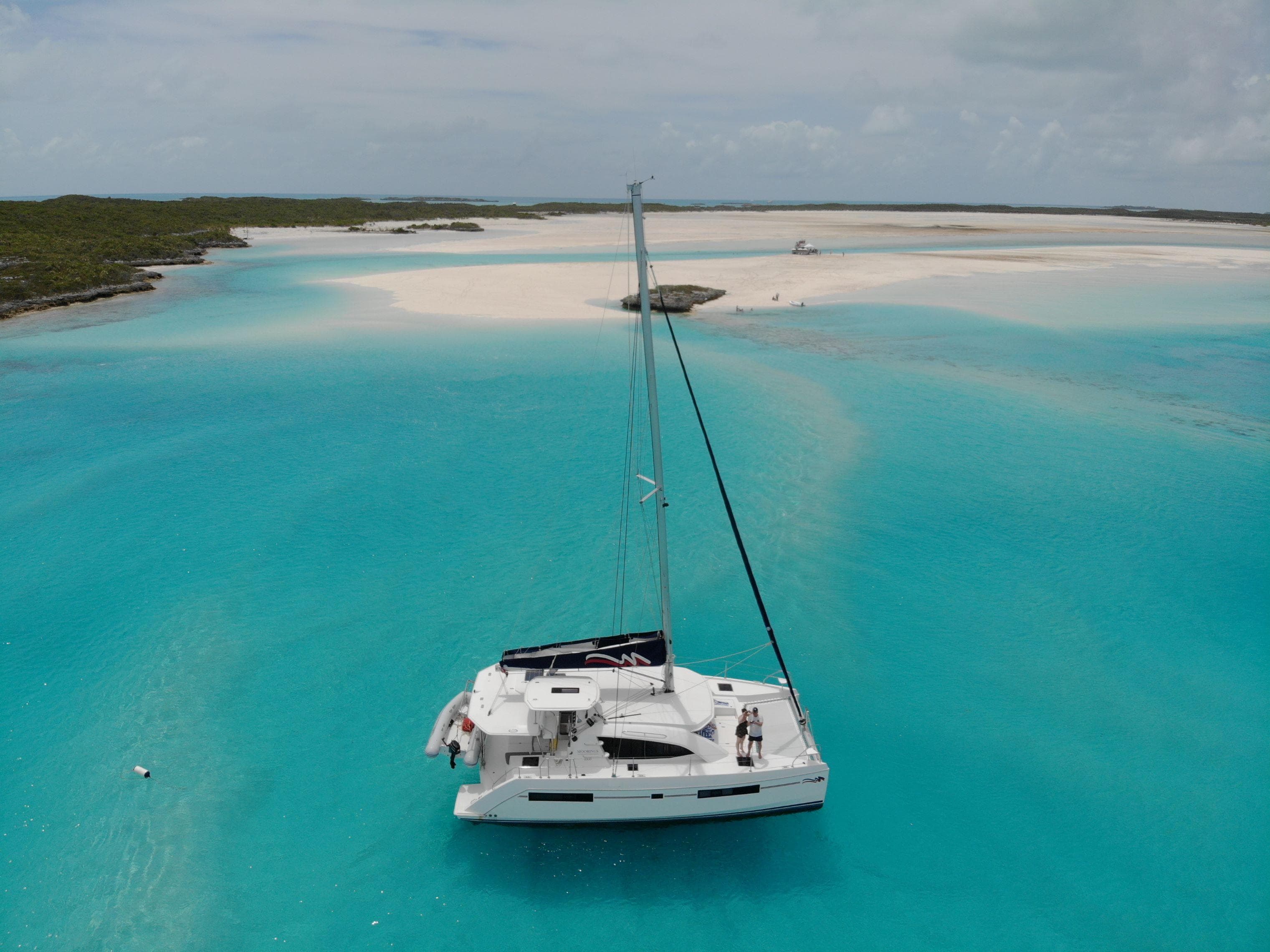 Leopard 40 catamaran sailing in turquoise waters near sandy beach, 2020 model.