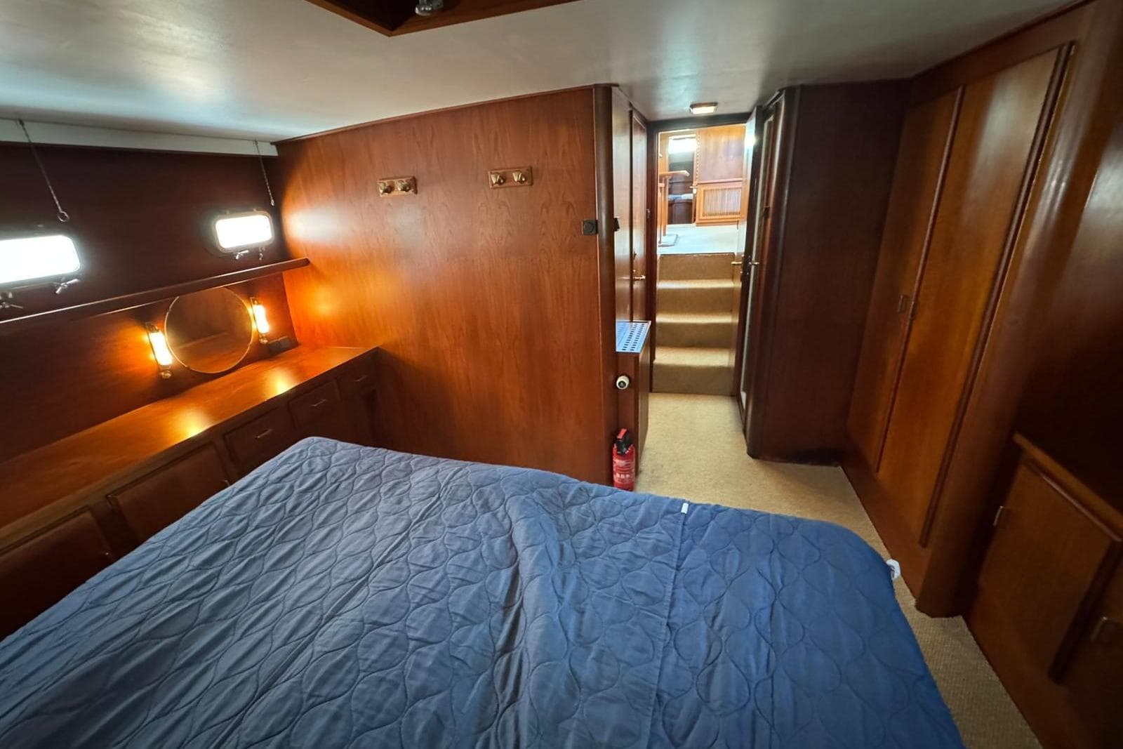 Luxurious cabin interior of 1991 Super Van Craft 15.50 yacht with wood paneling and blue bedding.