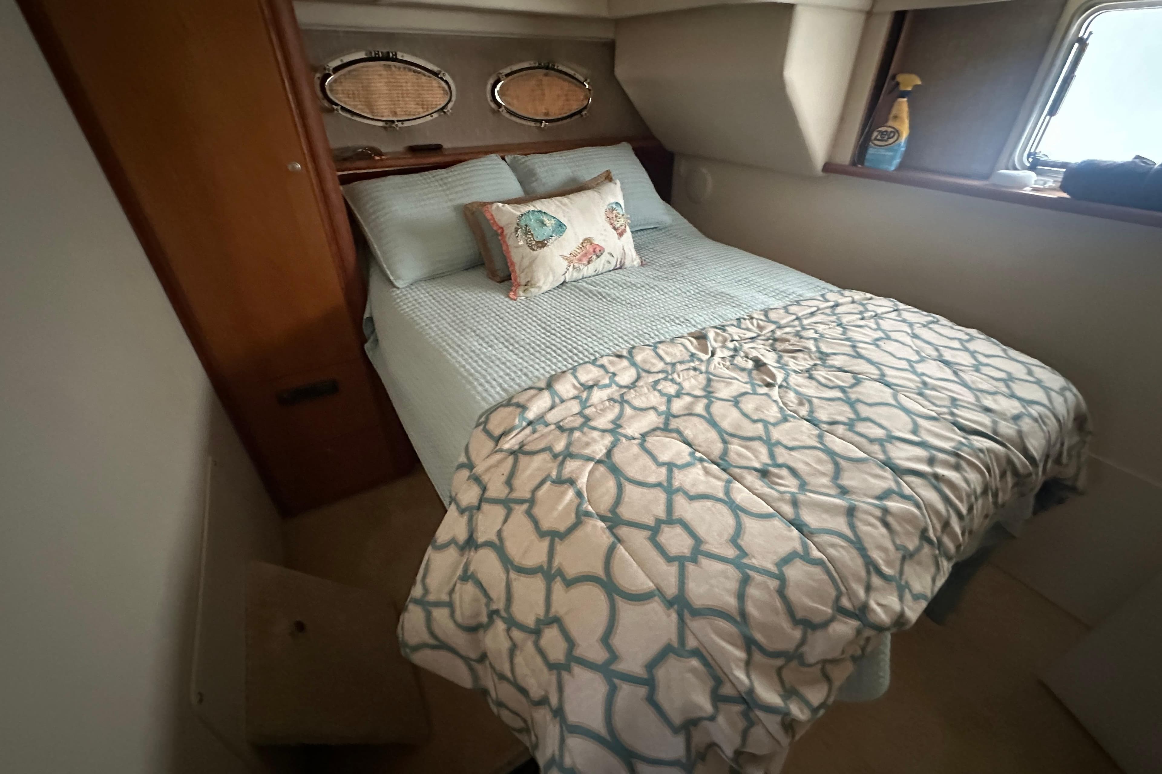 Cozy bedroom in 1998 Silverton 372 Motor Yacht with nautical-themed bedding.