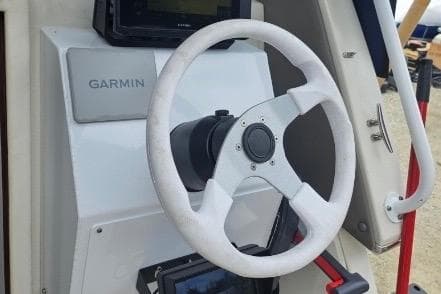 1997 Skipjack 262 Flybridge helm with Garmin navigation system and steering wheel.