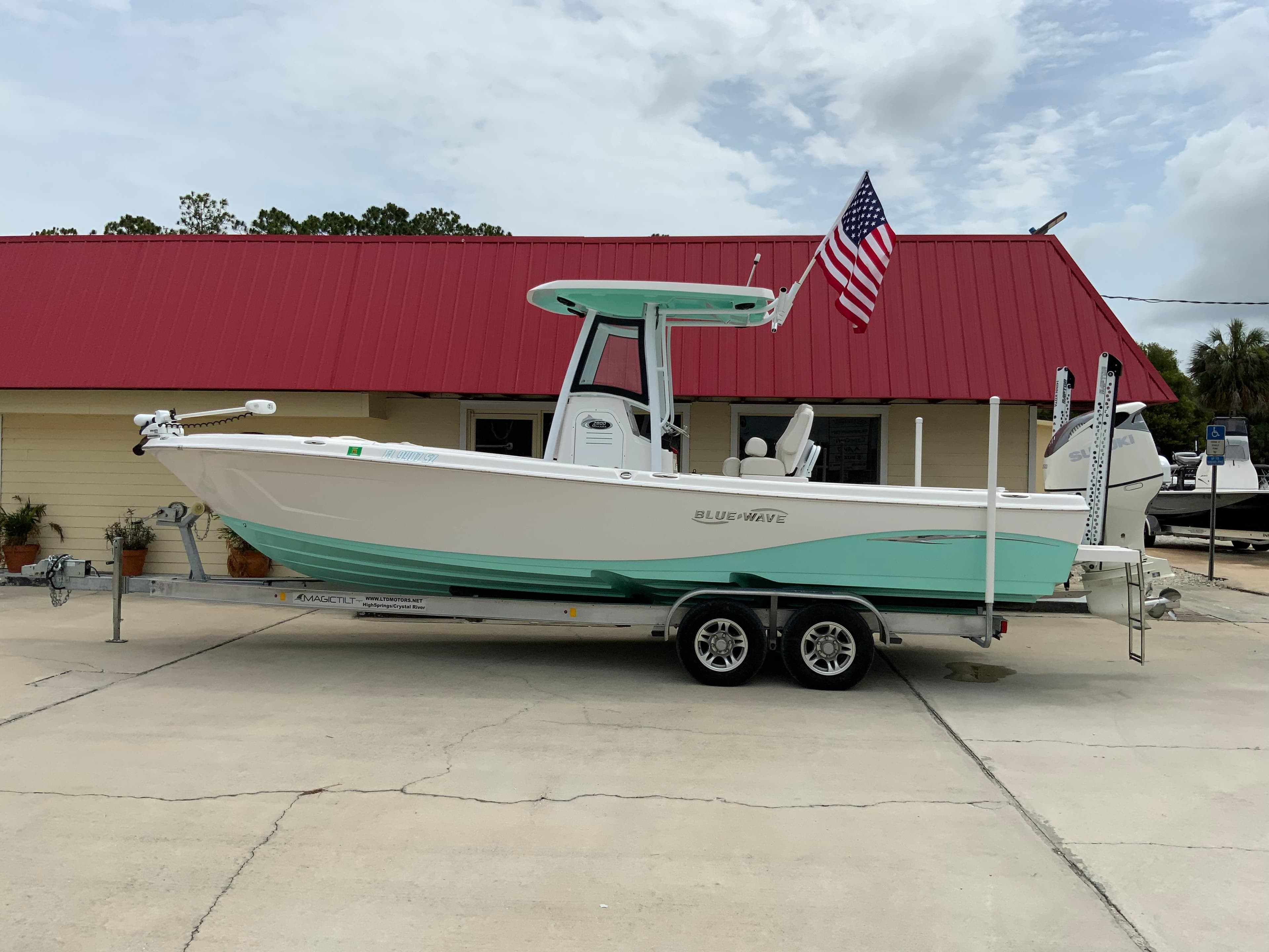 2021 Blue Wave 2800 Makaira boat on trailer with American flag.