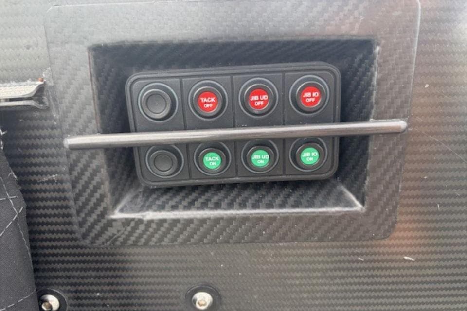 Control panel with buttons on a 2023 Carkeek 45, featuring carbon fiber finish.