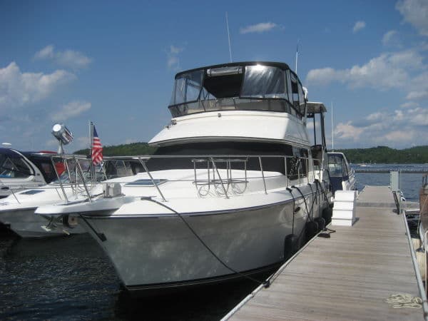 1990 Carver 3608 Aft Cabin Motor Yacht docked at marina under blue sky.