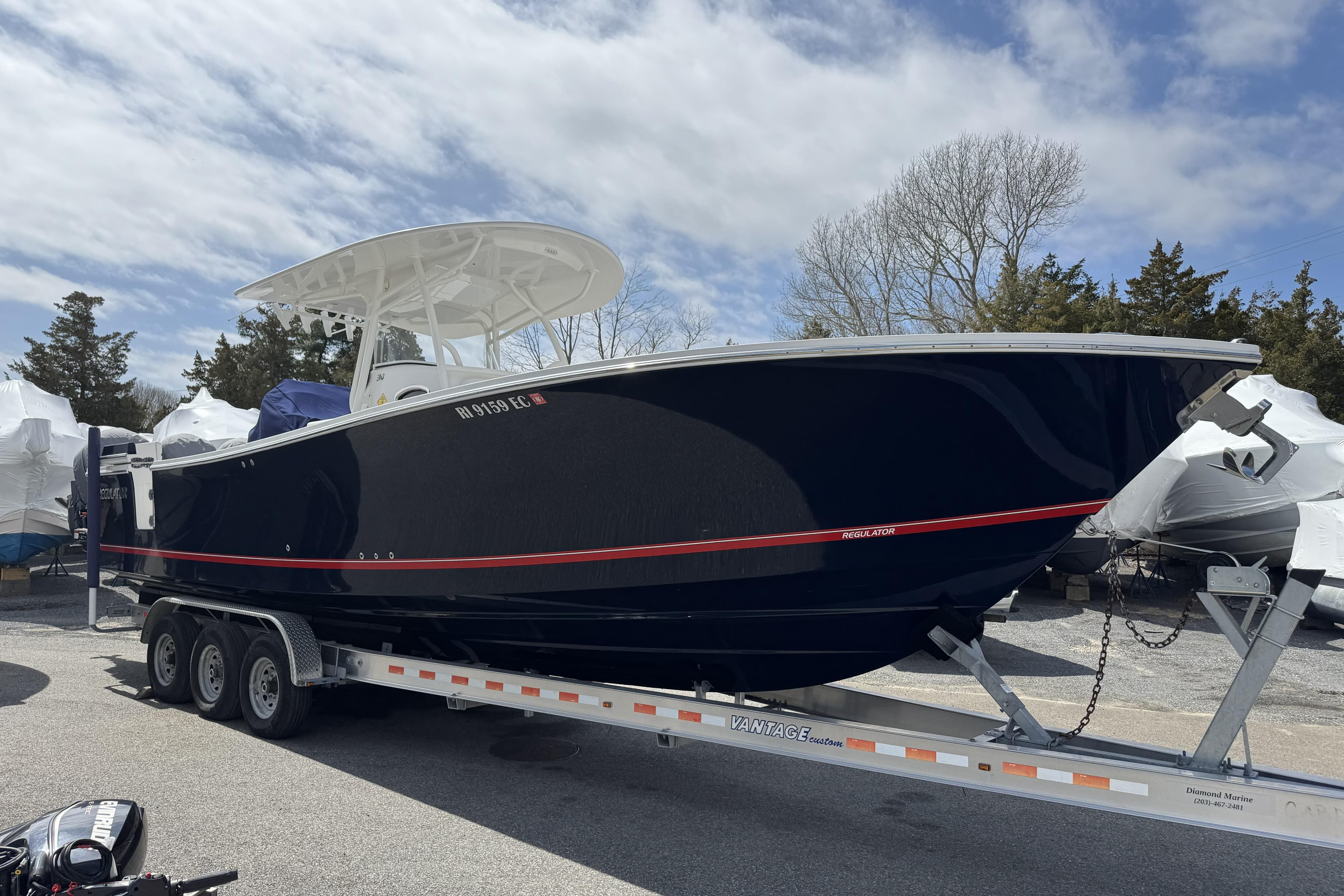 2018 Regulator 34SS boat on trailer, parked outdoors under cloudy sky.