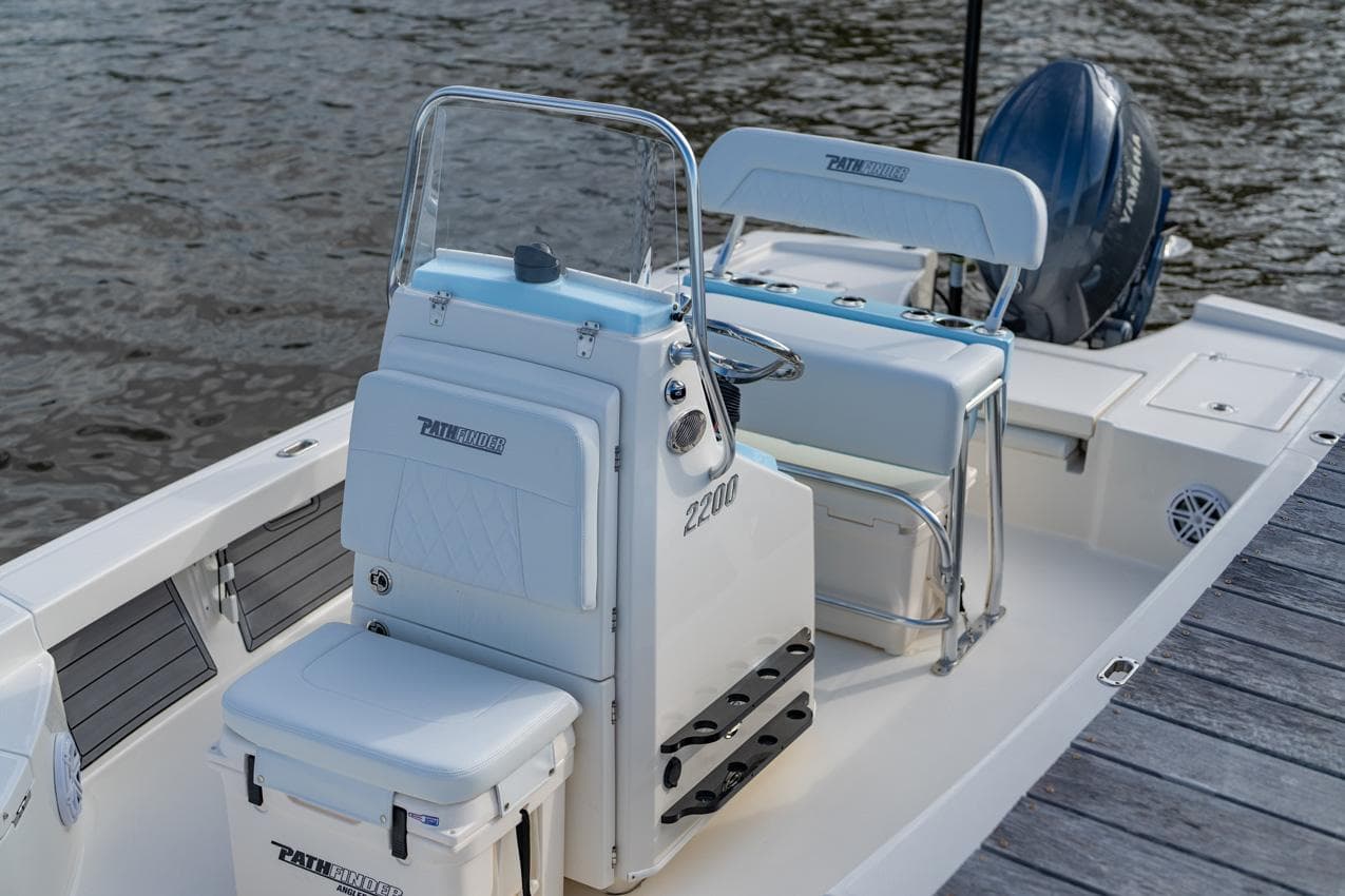 Manufacturer Provided Image: 2026 Pathfinder 2200 TRS boat interior with seating and console, docked by the water.