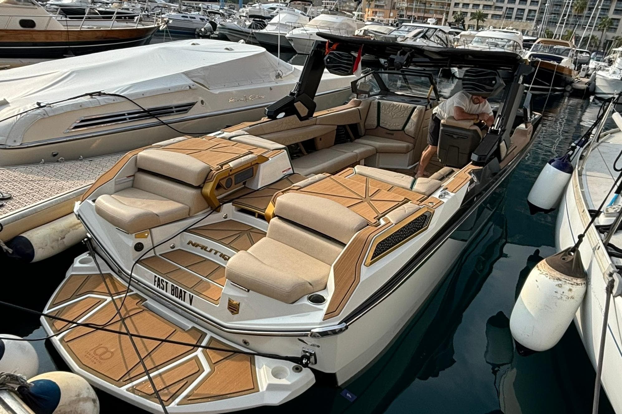 2024 Nautique Super Air Nautique Paragon 25 boat docked in marina, featuring luxurious seating.