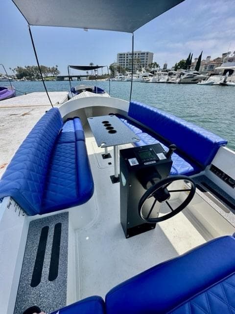 2023 Vision Marine Technologies Fantail 217 boat with blue seating, docked at marina.