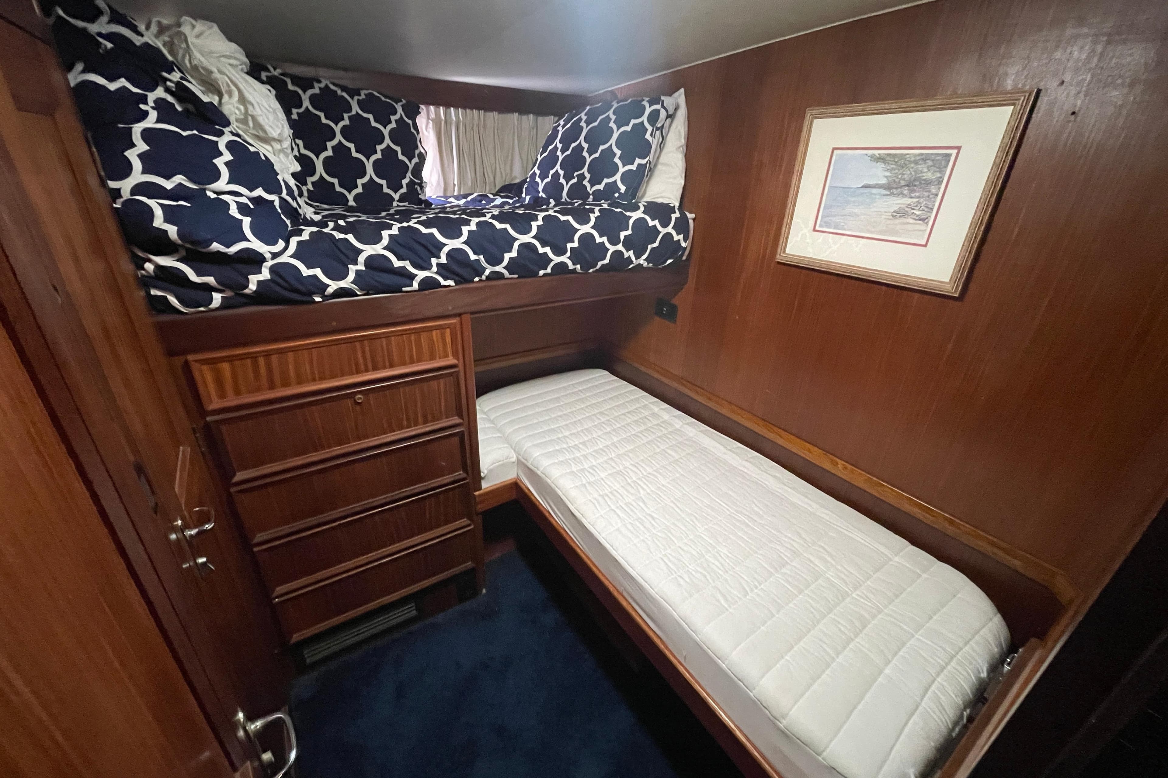 1981 Hatteras 48 Motor Yacht cabin with bunk beds, wood paneling, and nautical decor.