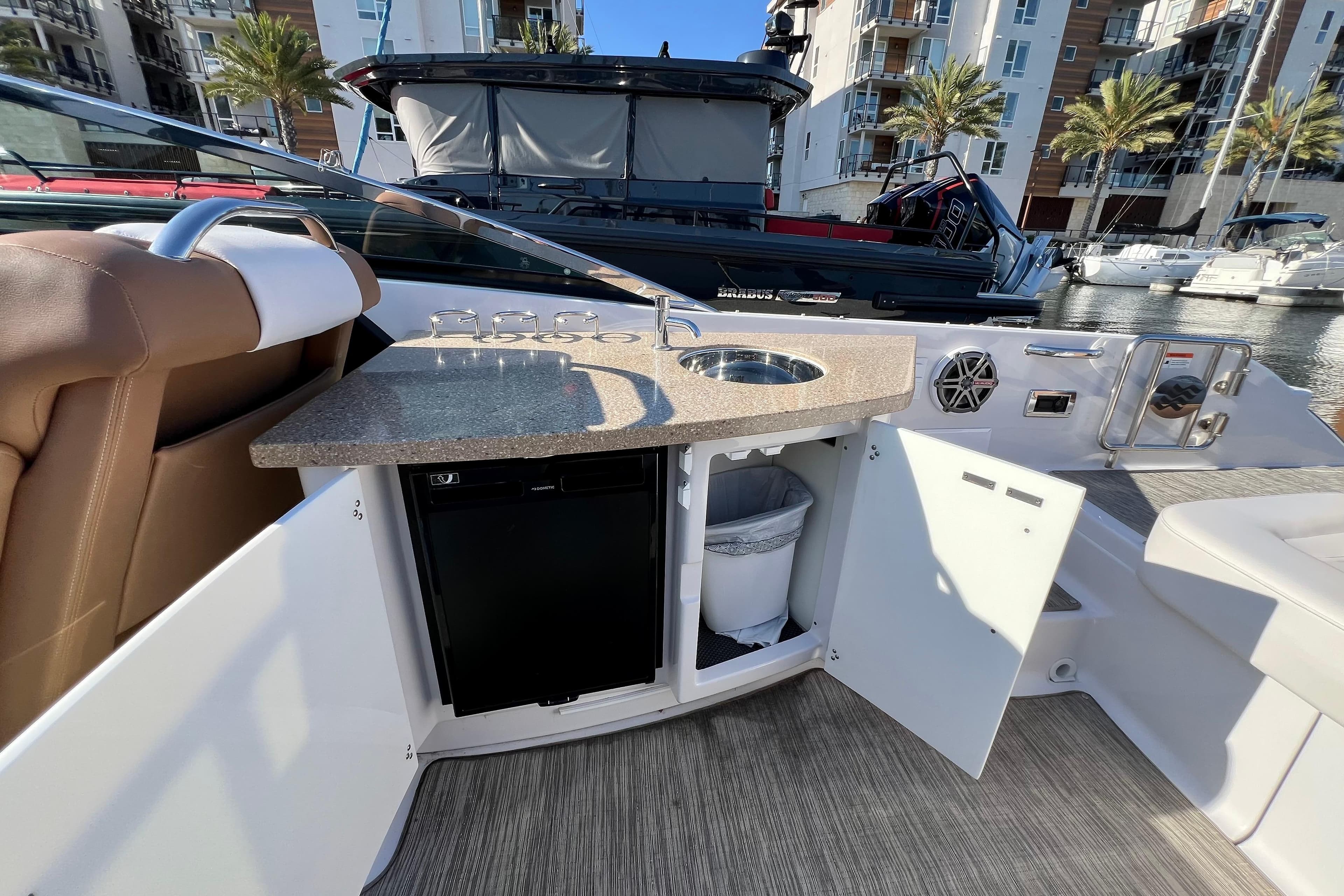 2019 Four Winns Horizon H290 boat interior with kitchenette and seating area.