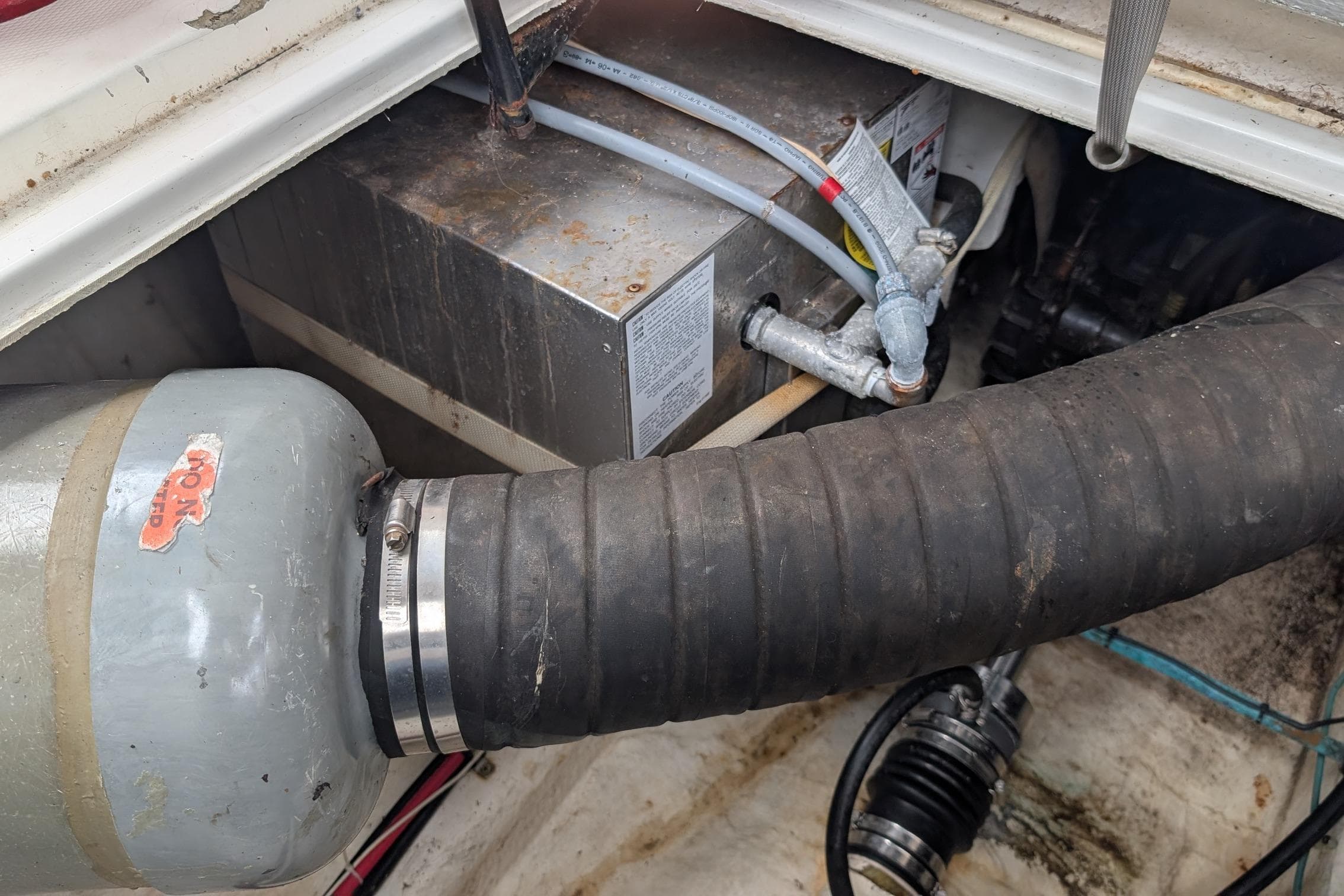 Engine compartment of a 1990 Bayliner 3888 Motoryacht, showing hoses and mechanical components.