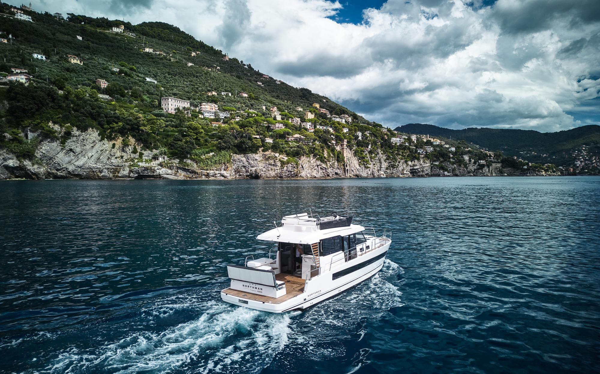 Luxury Northman 1300 yacht cruising near scenic coastline, 2025 model.