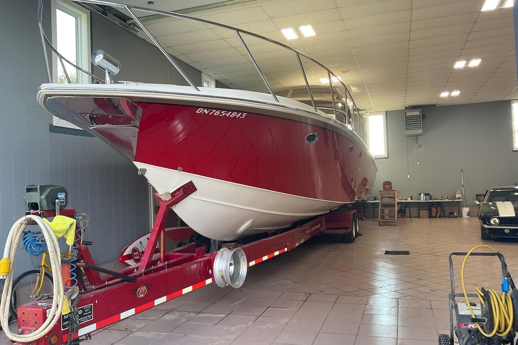 2005 Fountain 48 Express Cruiser in garage, red and white hull on trailer.