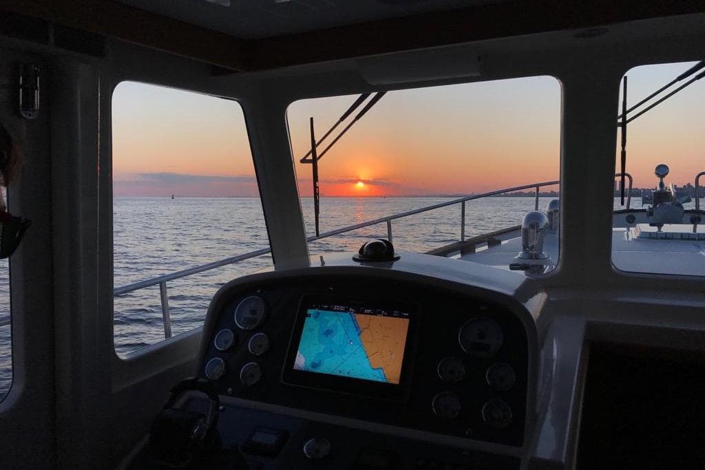 Rhea Trawler 36 Timonier 2014 navigating at sunset, featuring a nautical dashboard view.