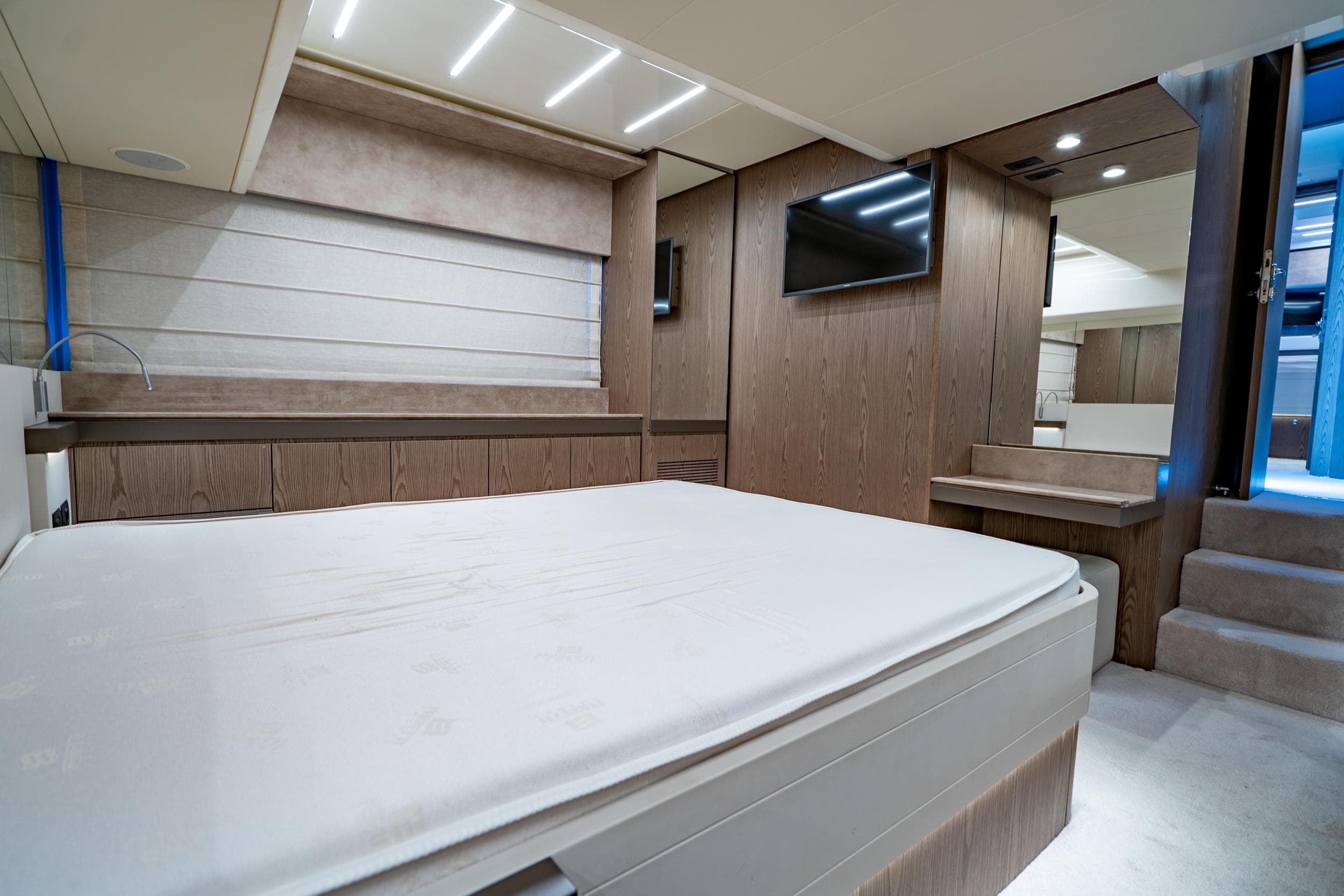 Luxurious bedroom interior of 2021 Ferretti Yachts 550, featuring modern design and elegant wood finishes.