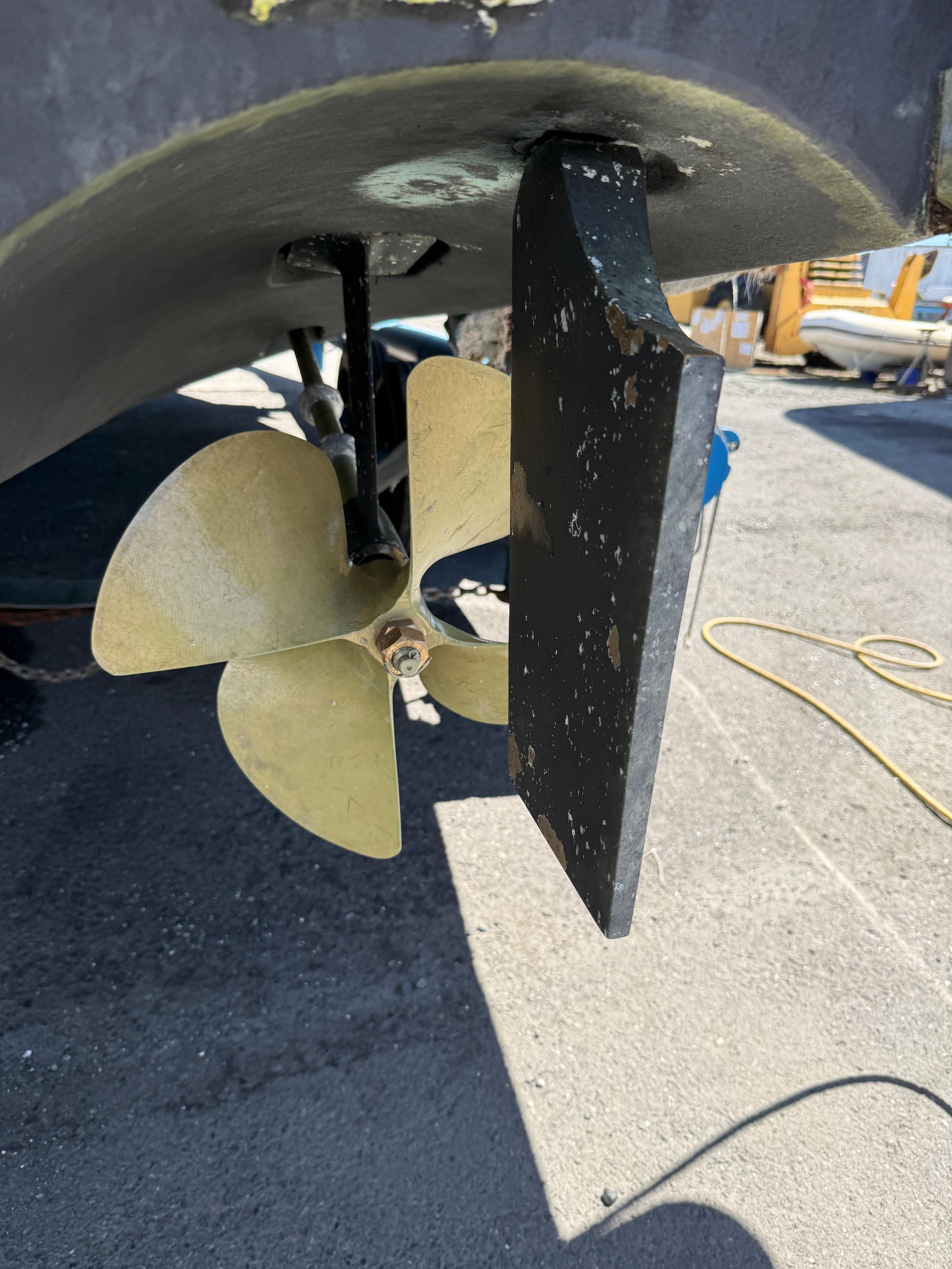 Propeller and rudder of 2008 Four Winns V358 boat on dry dock.