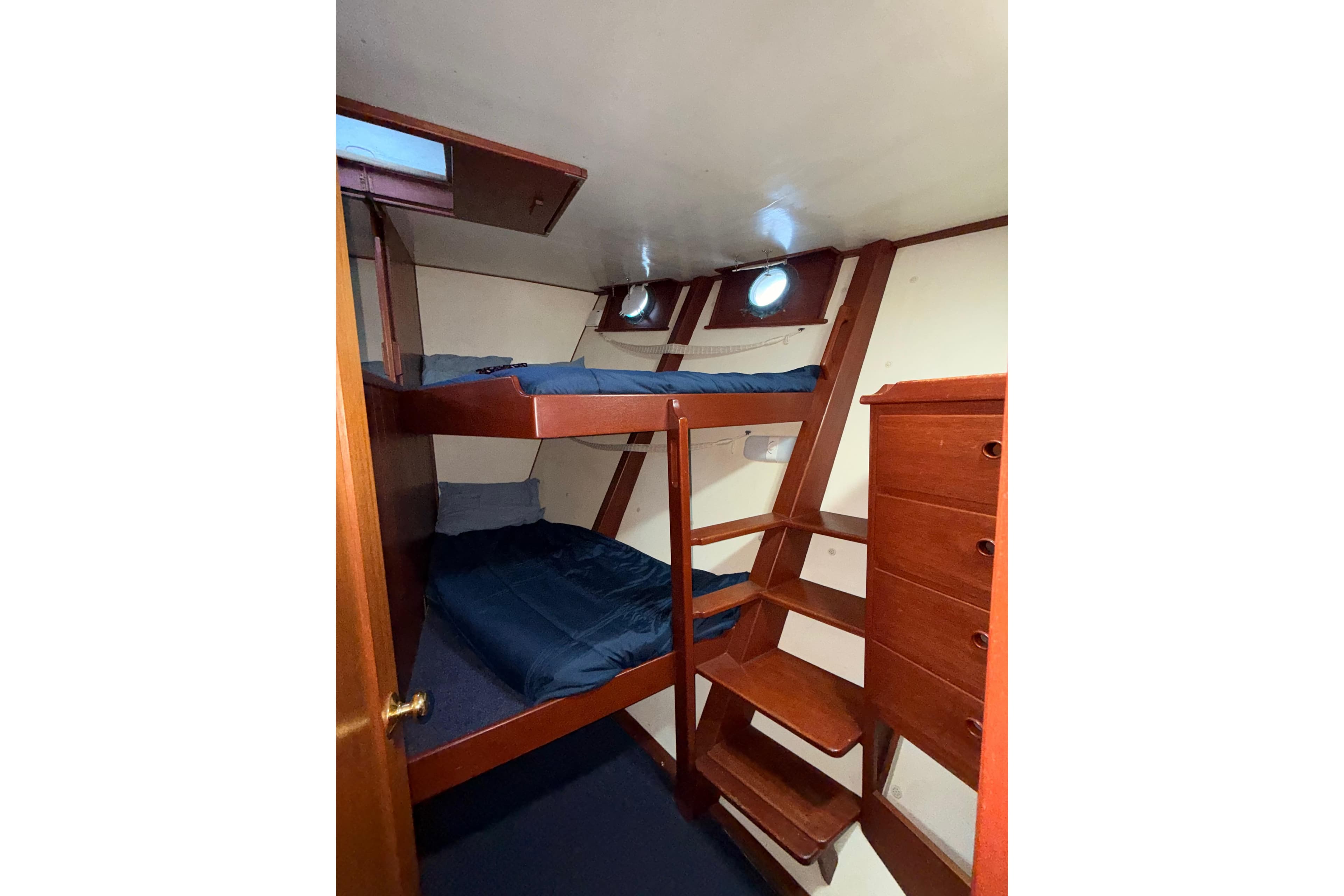 Interior of a 1965 Custom Trawler with wooden bunk beds and storage.