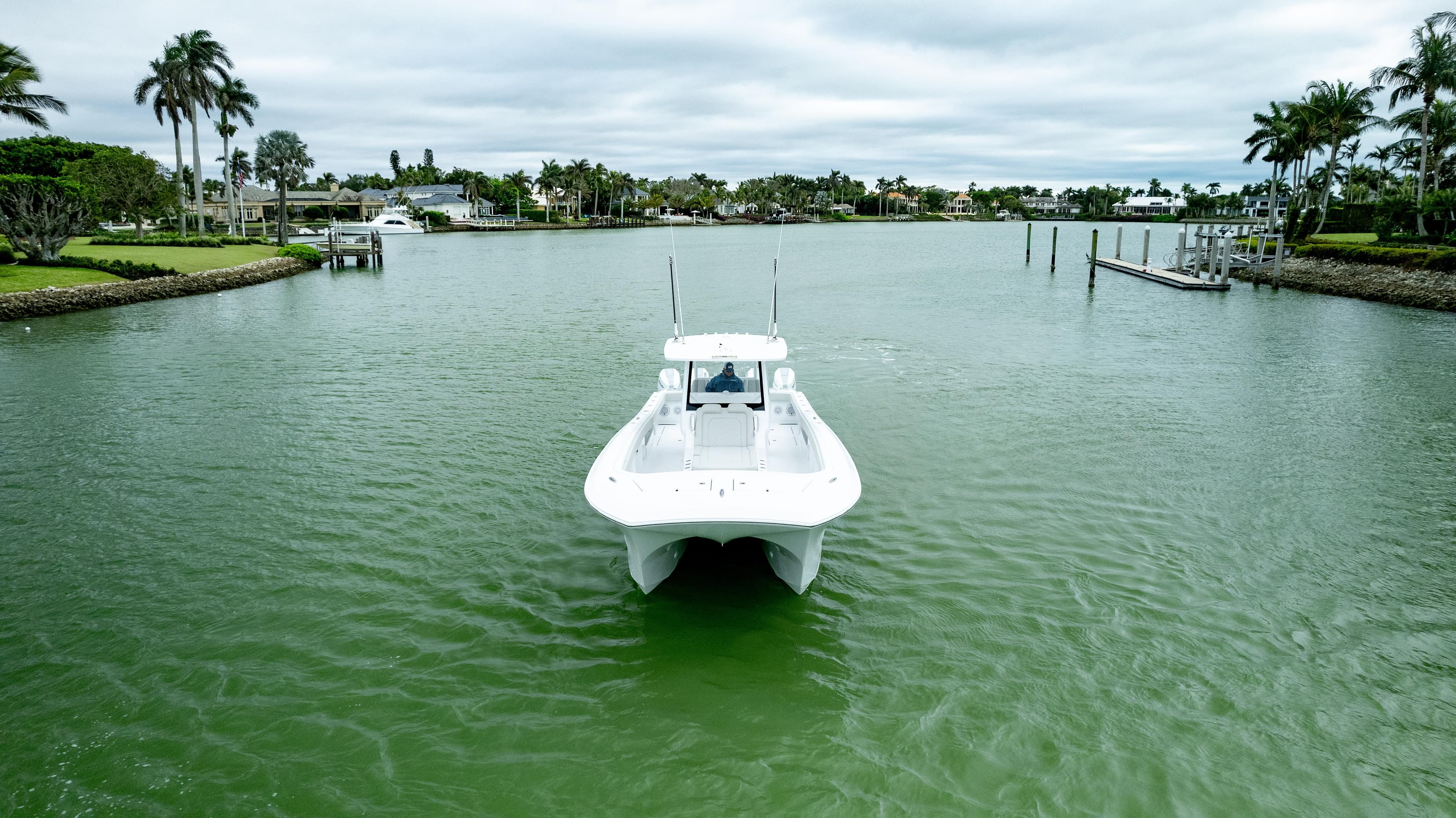 Front Runner 37 Catamaran 2025 cruising on a serene waterway with lush greenery.