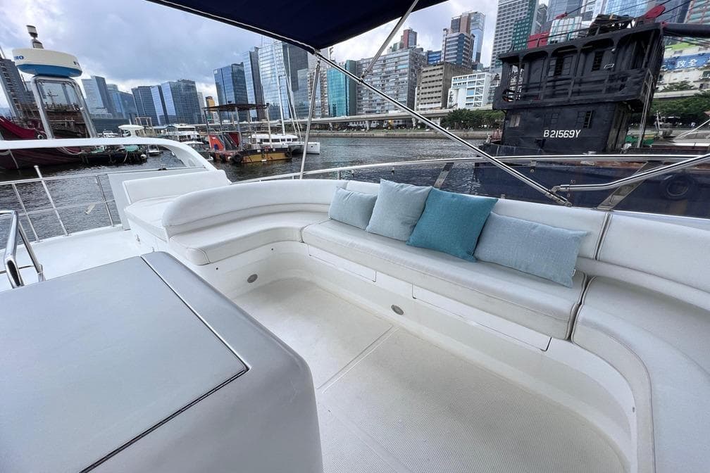 Luxurious seating area on a 2007 Grand Harbour Ruby 60 yacht, docked in an urban marina.